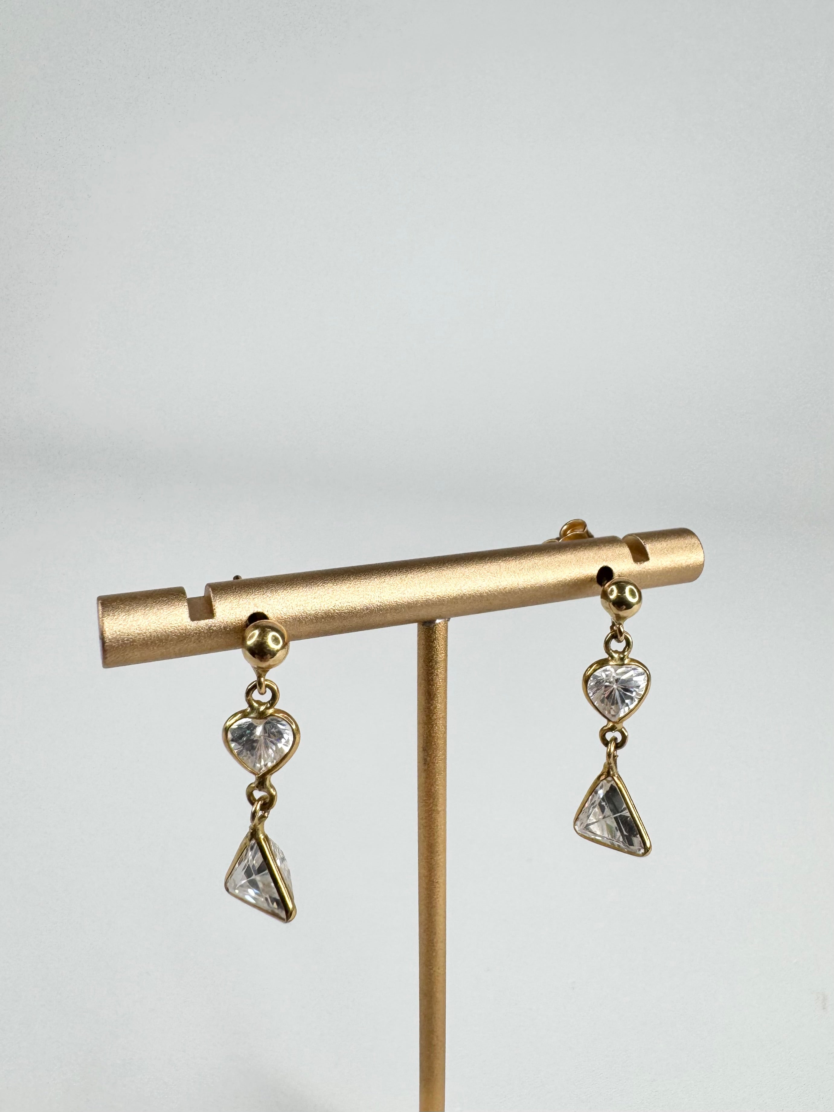 Gold Dangle earrings with two crystals on a gold earring stand against a white background