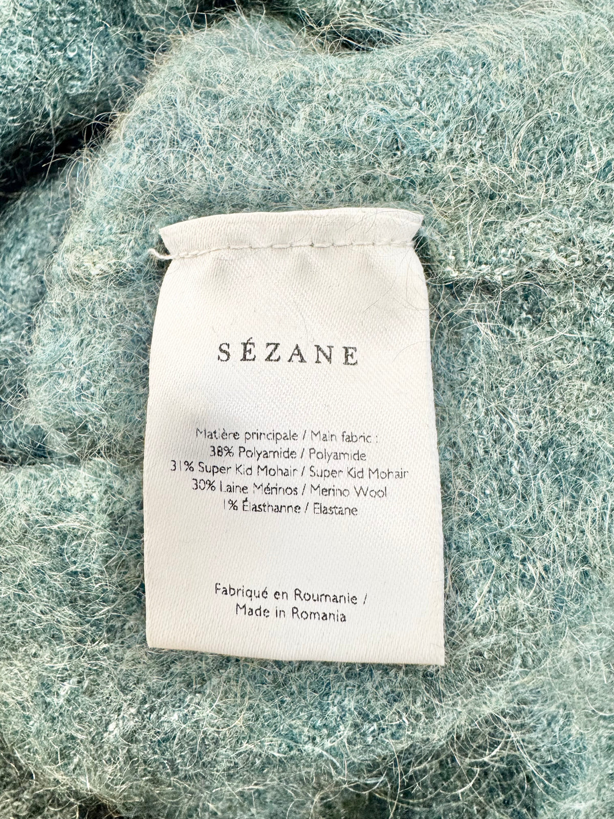 Sézane label on a textured fabric background