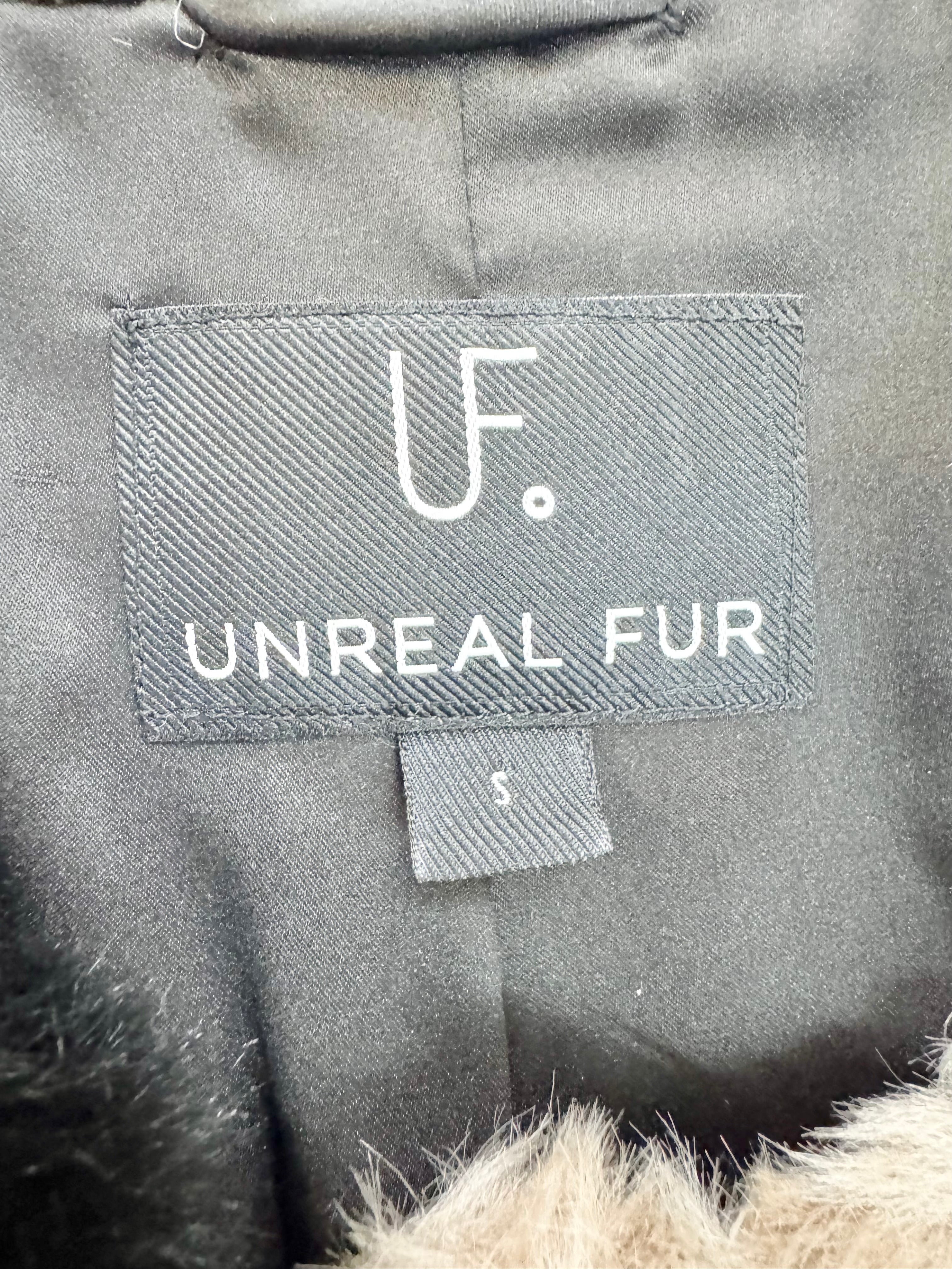Label on a gray garment with 'Unreal Fur' branding.