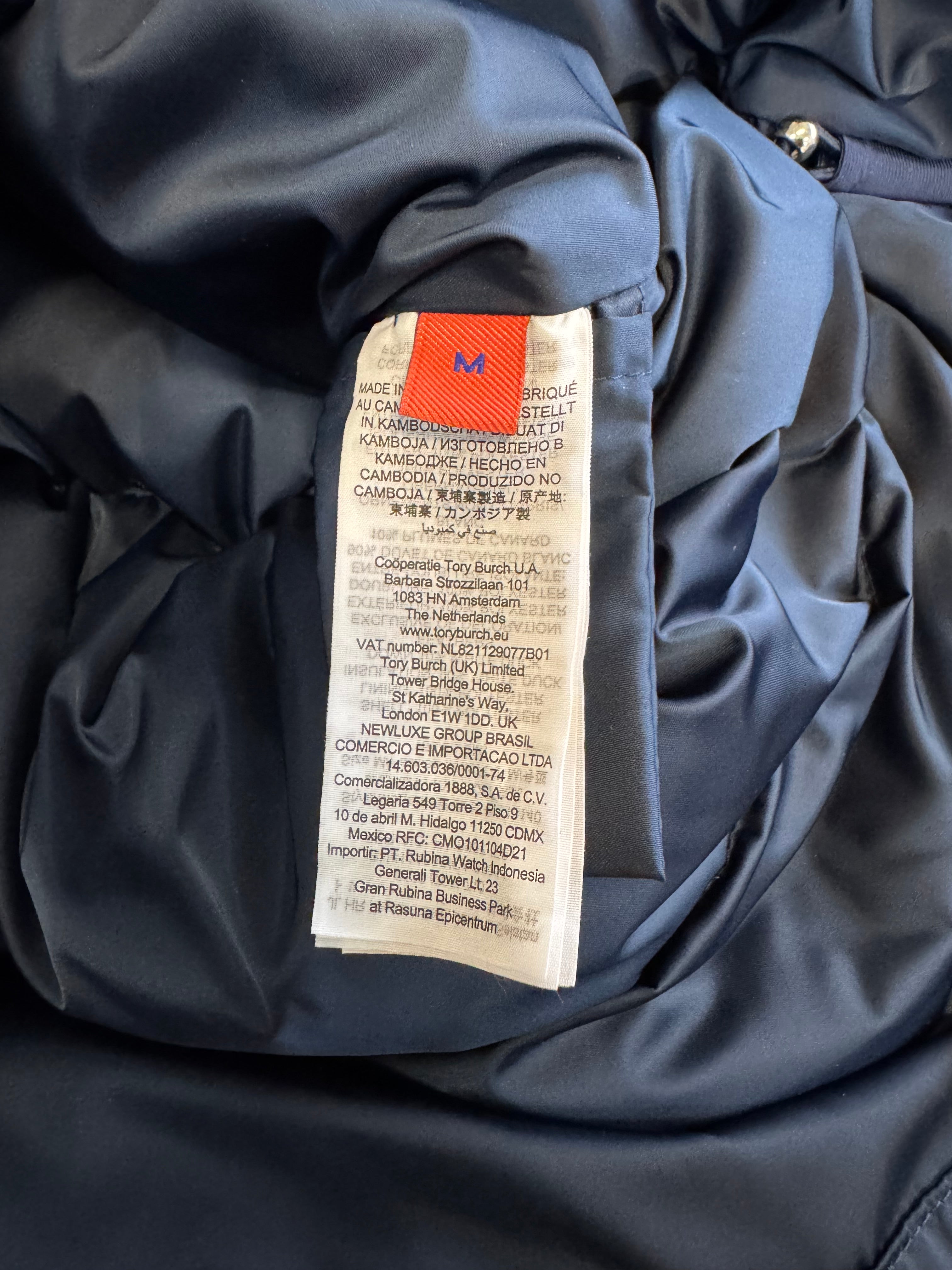 Close-up of a label inside a dark jacket with text and a red tag.