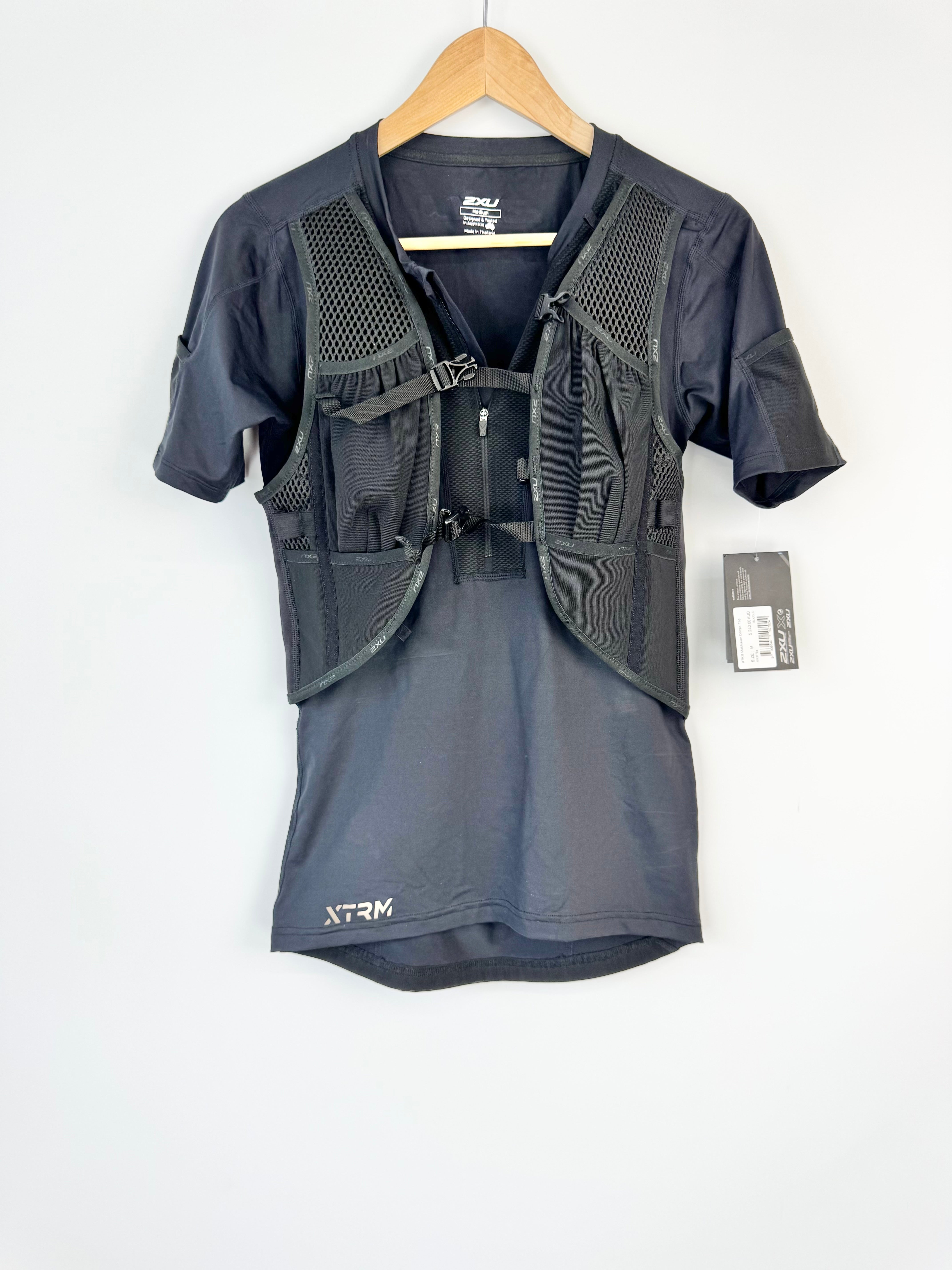 Black athletic shirt with a vest on a hanger against a white background