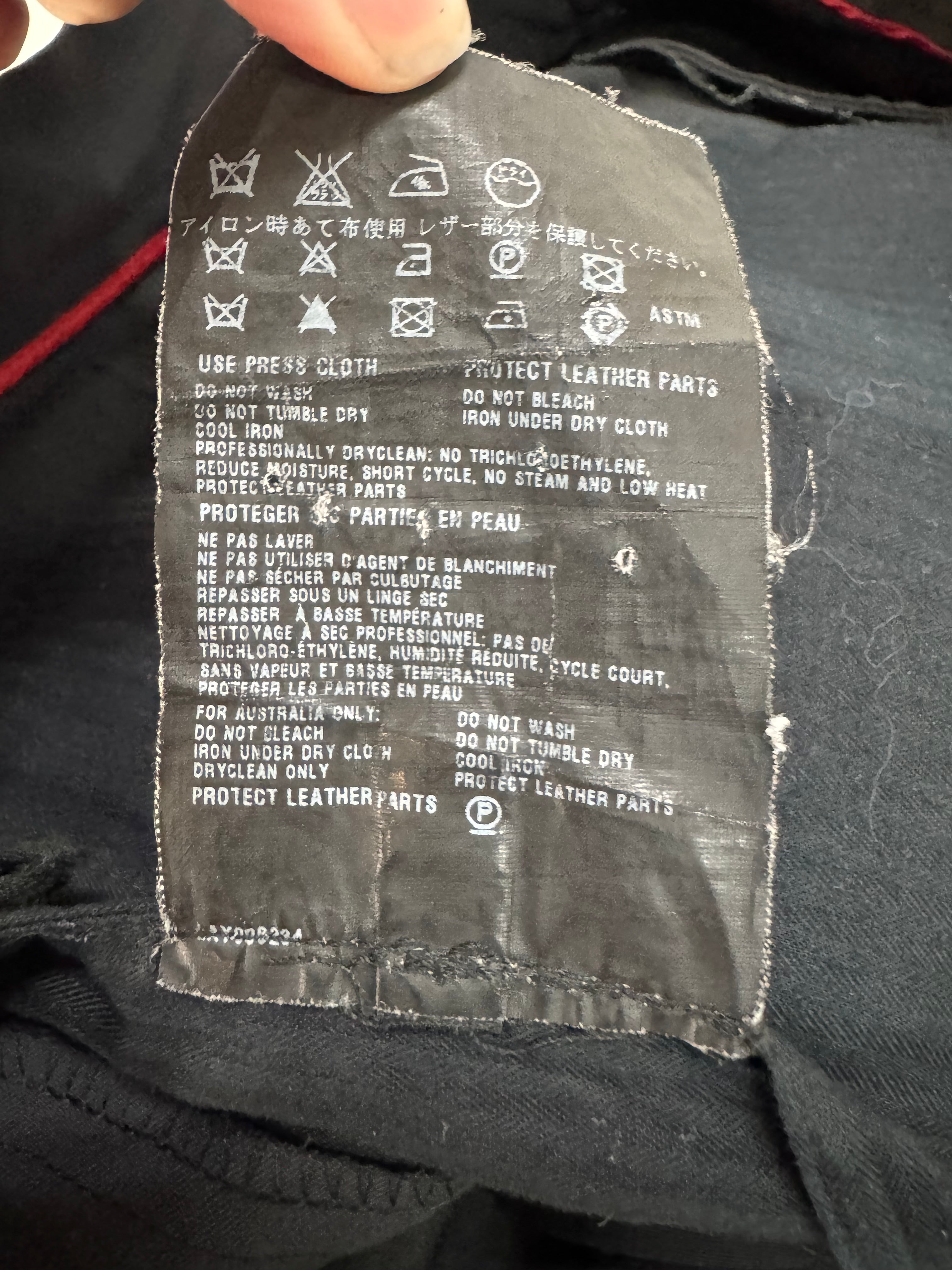 Clothing label with text and symbols on a dark fabric background