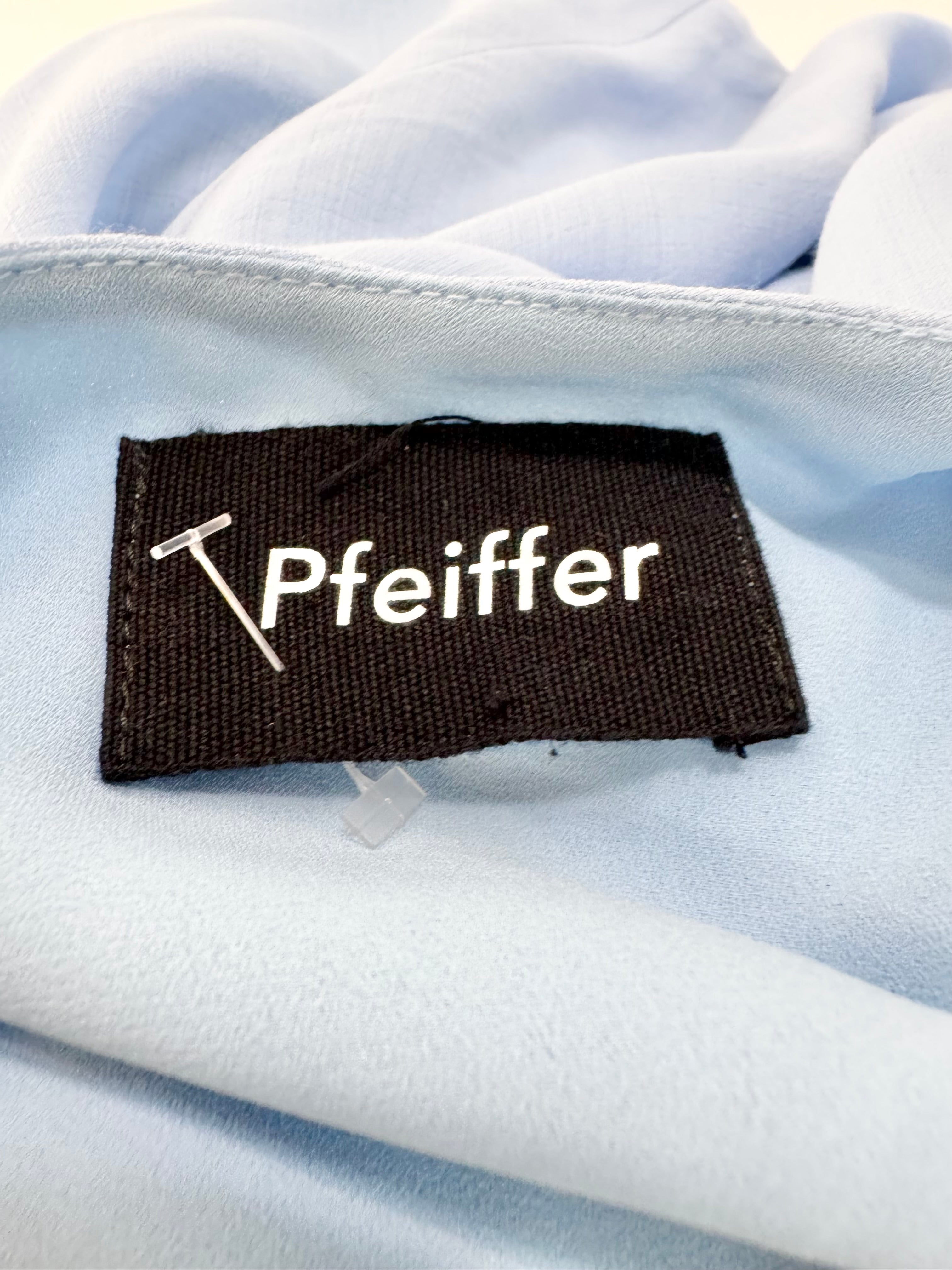 Close-up of a Pfeiffer label on a light blue fabric background