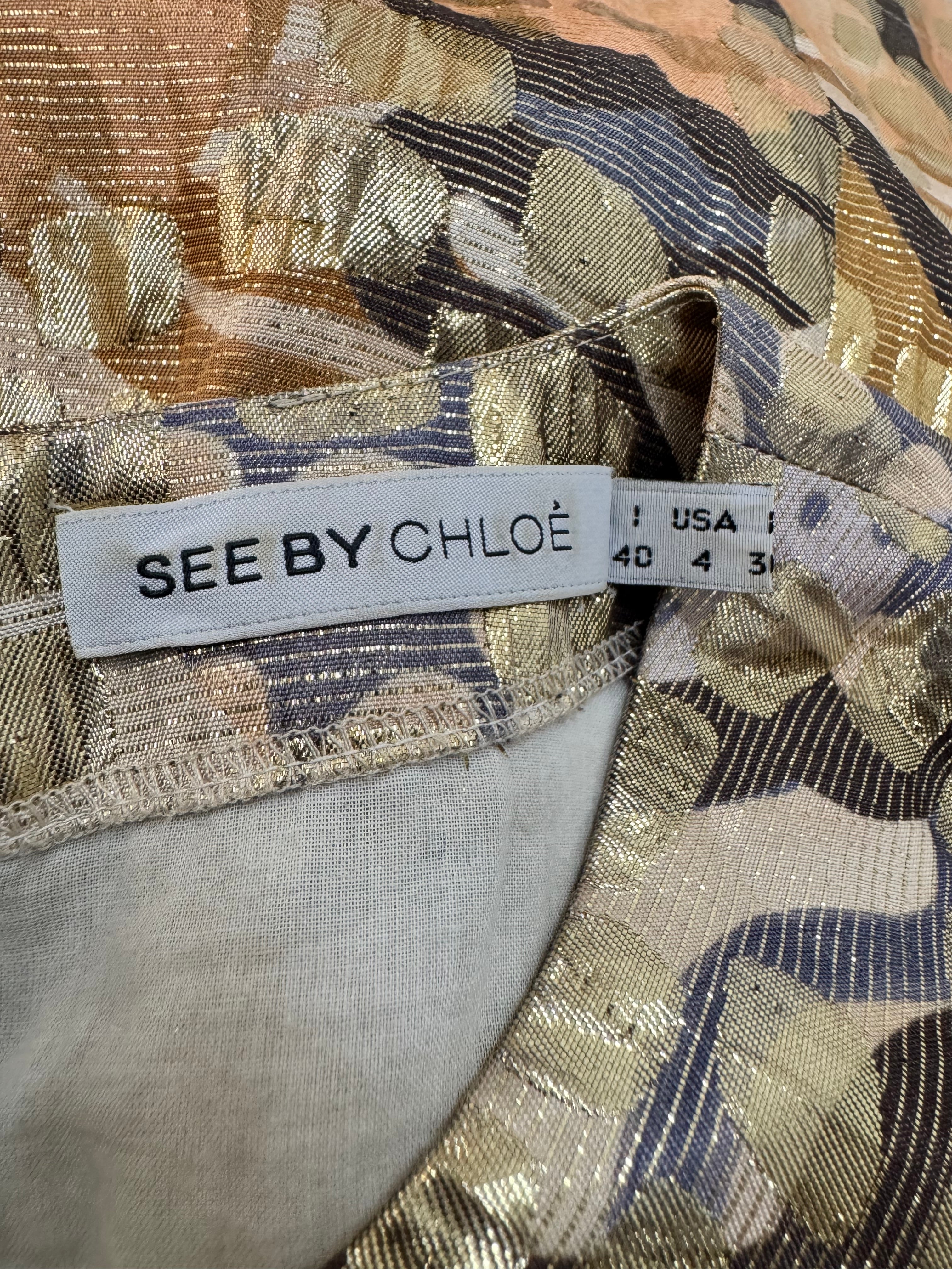 Close-up of a 'See by Chloé' label on a patterned fabric background