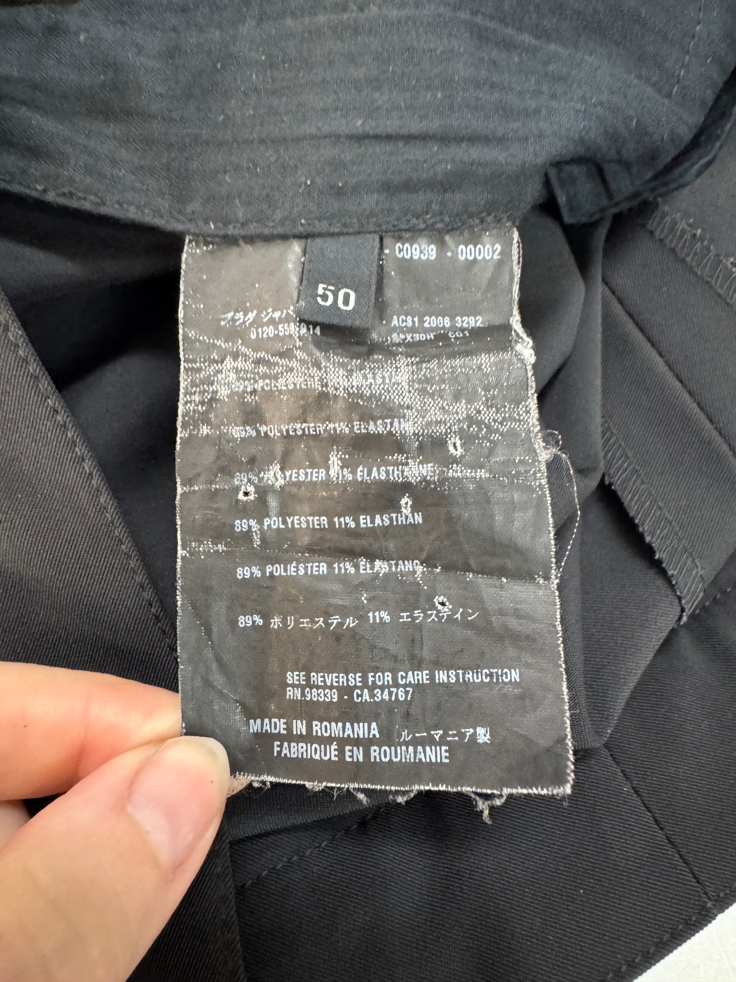 Close-up of a clothing label on a black garment with text and size information.