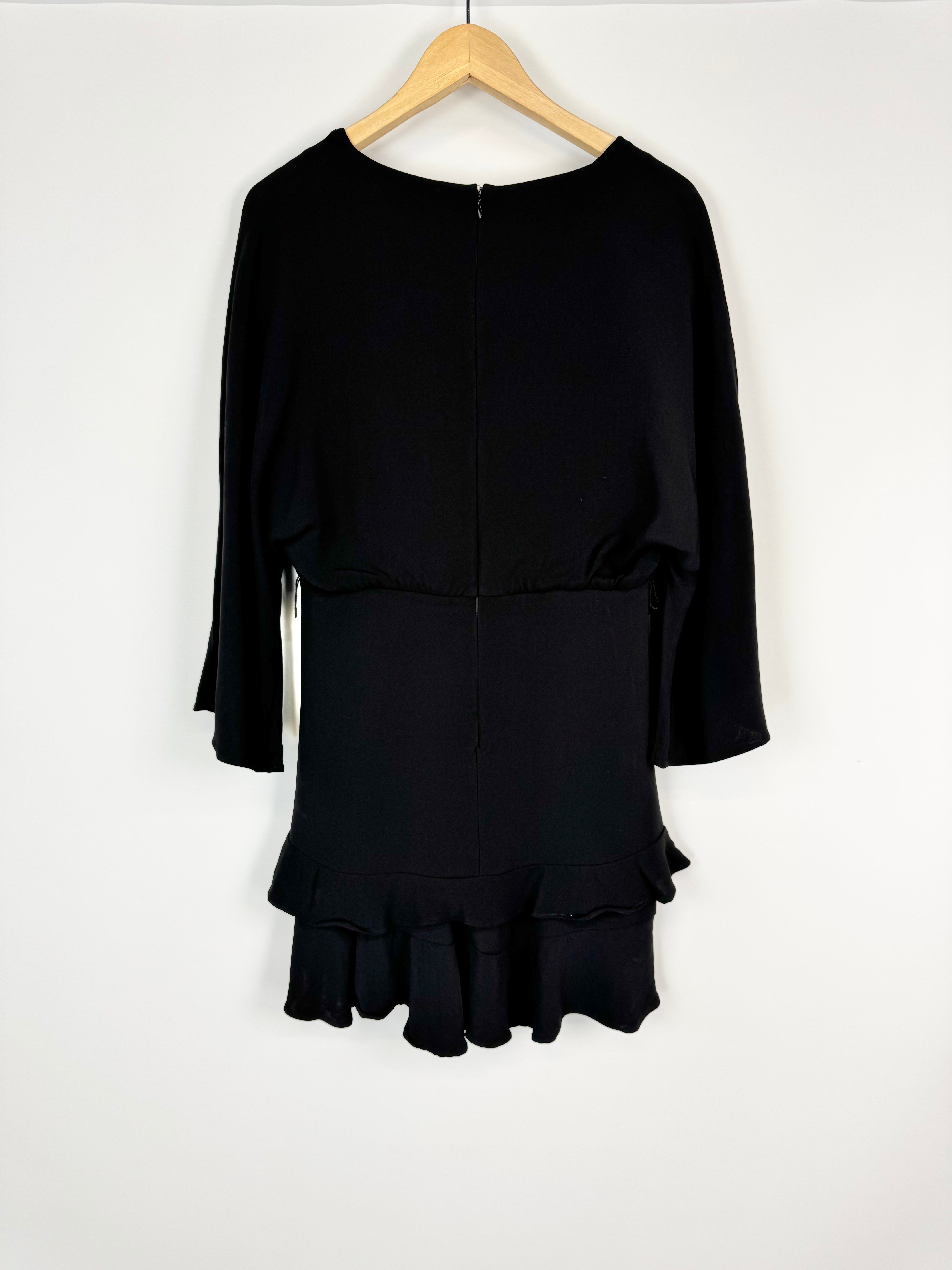 Black long-sleeve top and skirt set on a hanger against a white background