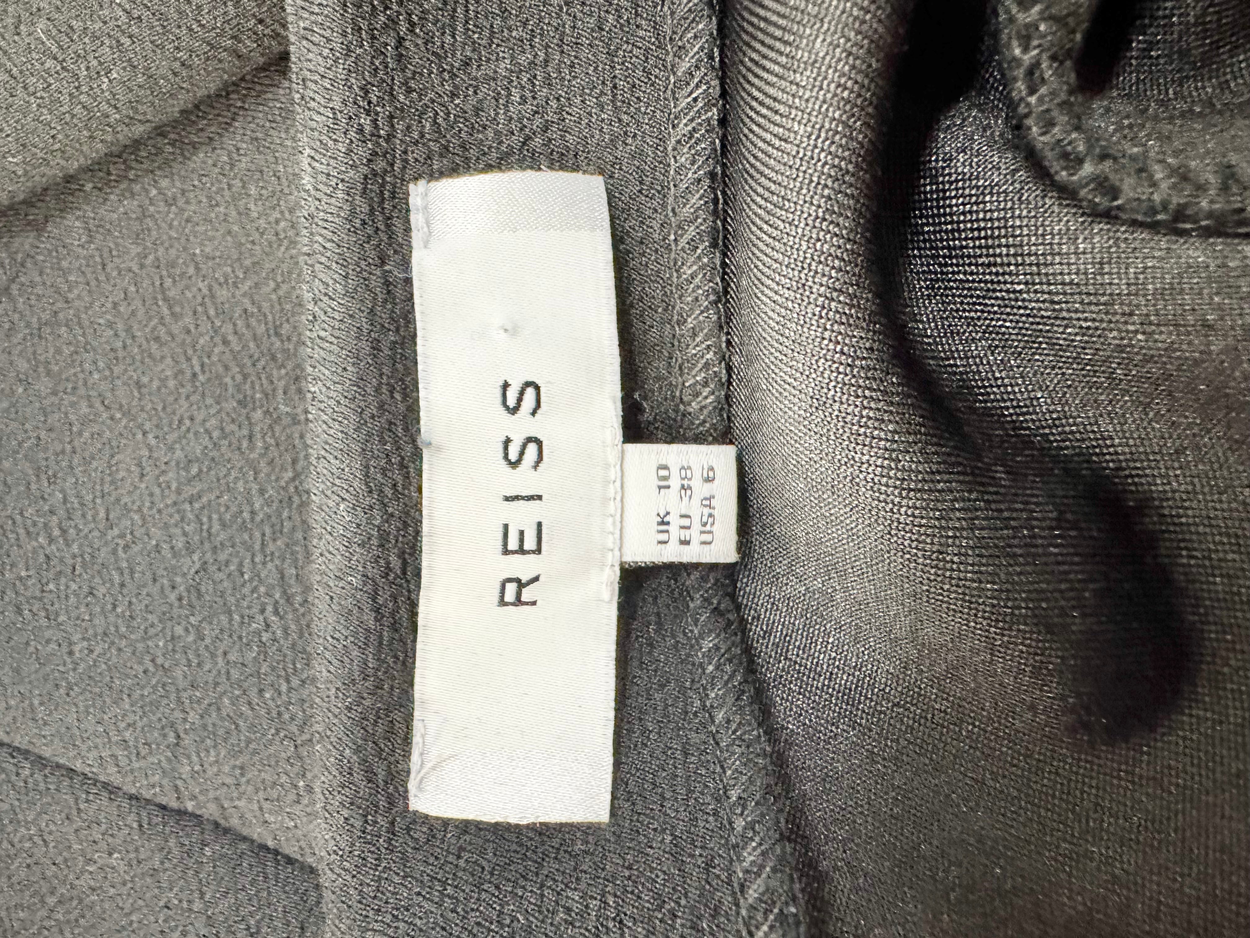 Close-up of a REISS label on a textured fabric background