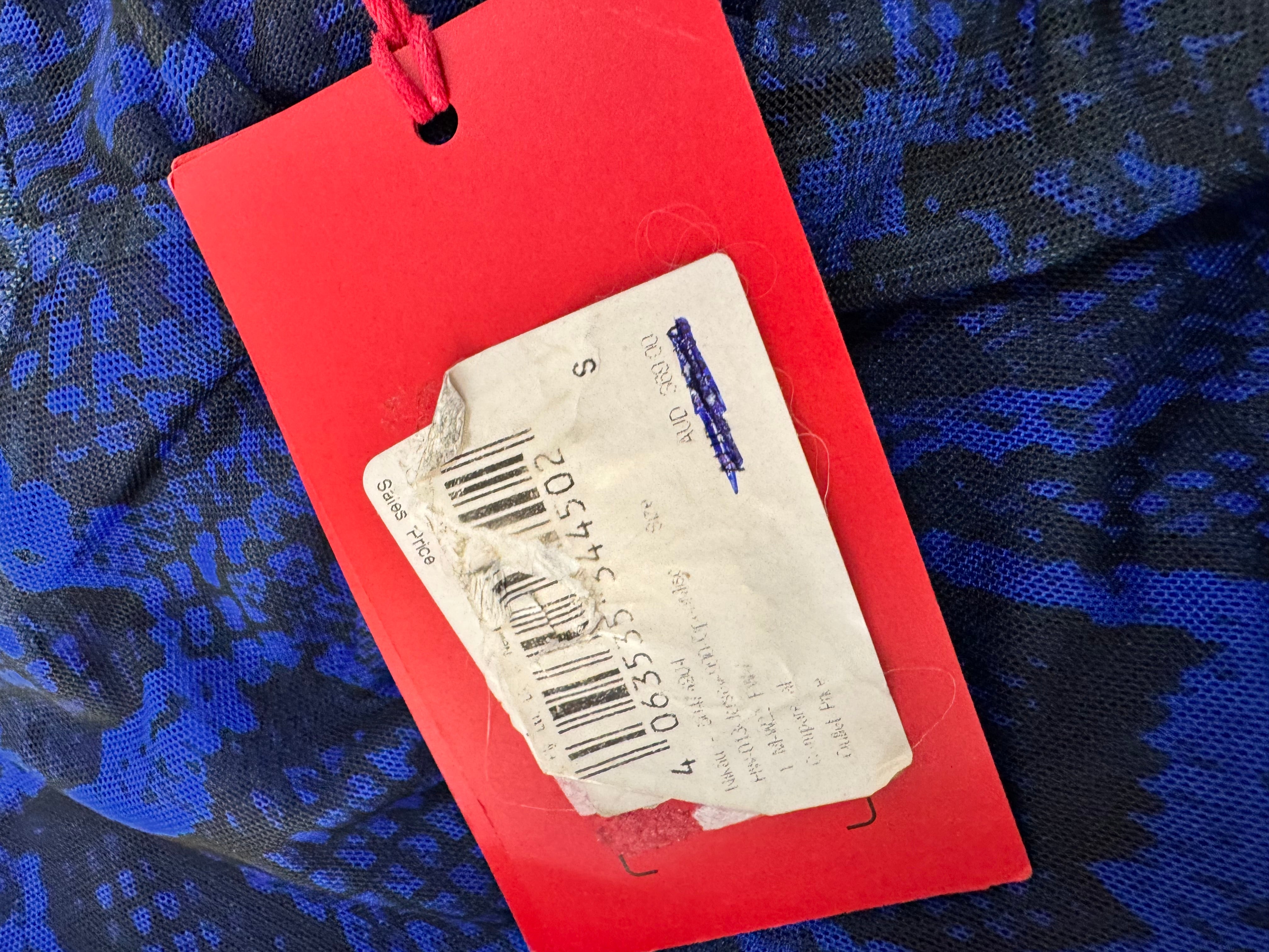 Red tag with a barcode on a blue camouflage fabric background