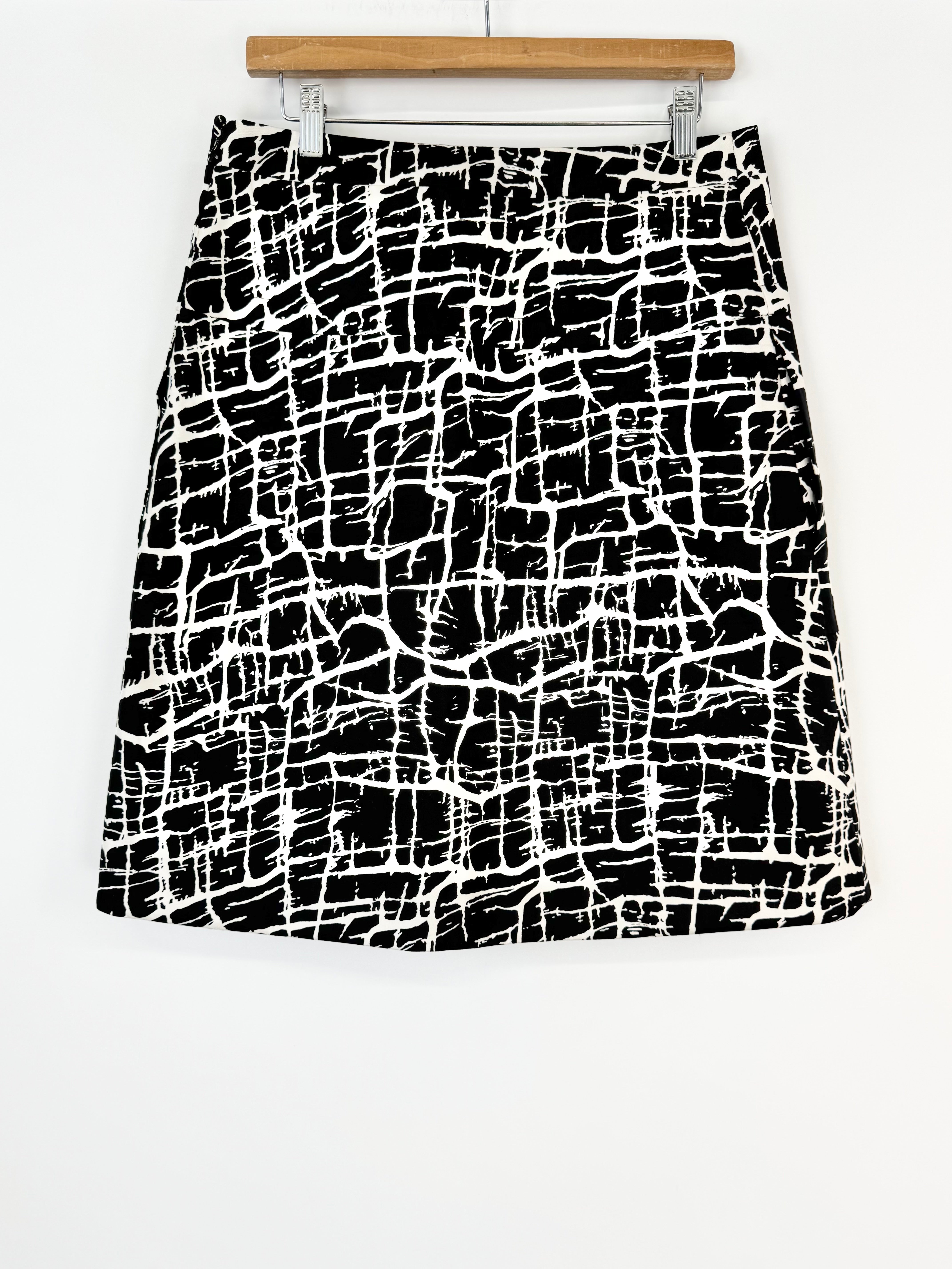 Black and white patterned skirt on a hanger against a white background
