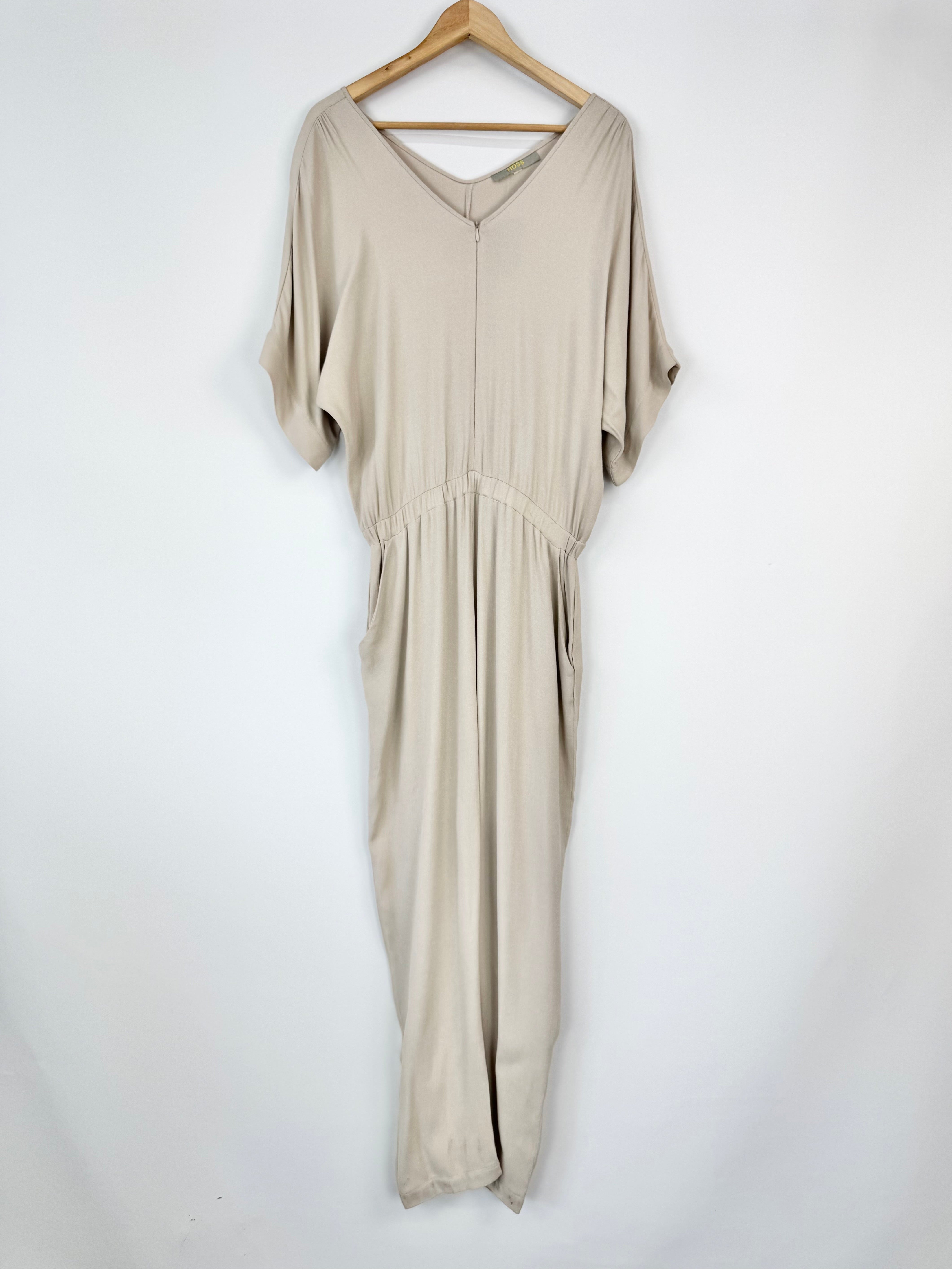 Beige dress hanging on a wooden hanger against a white background