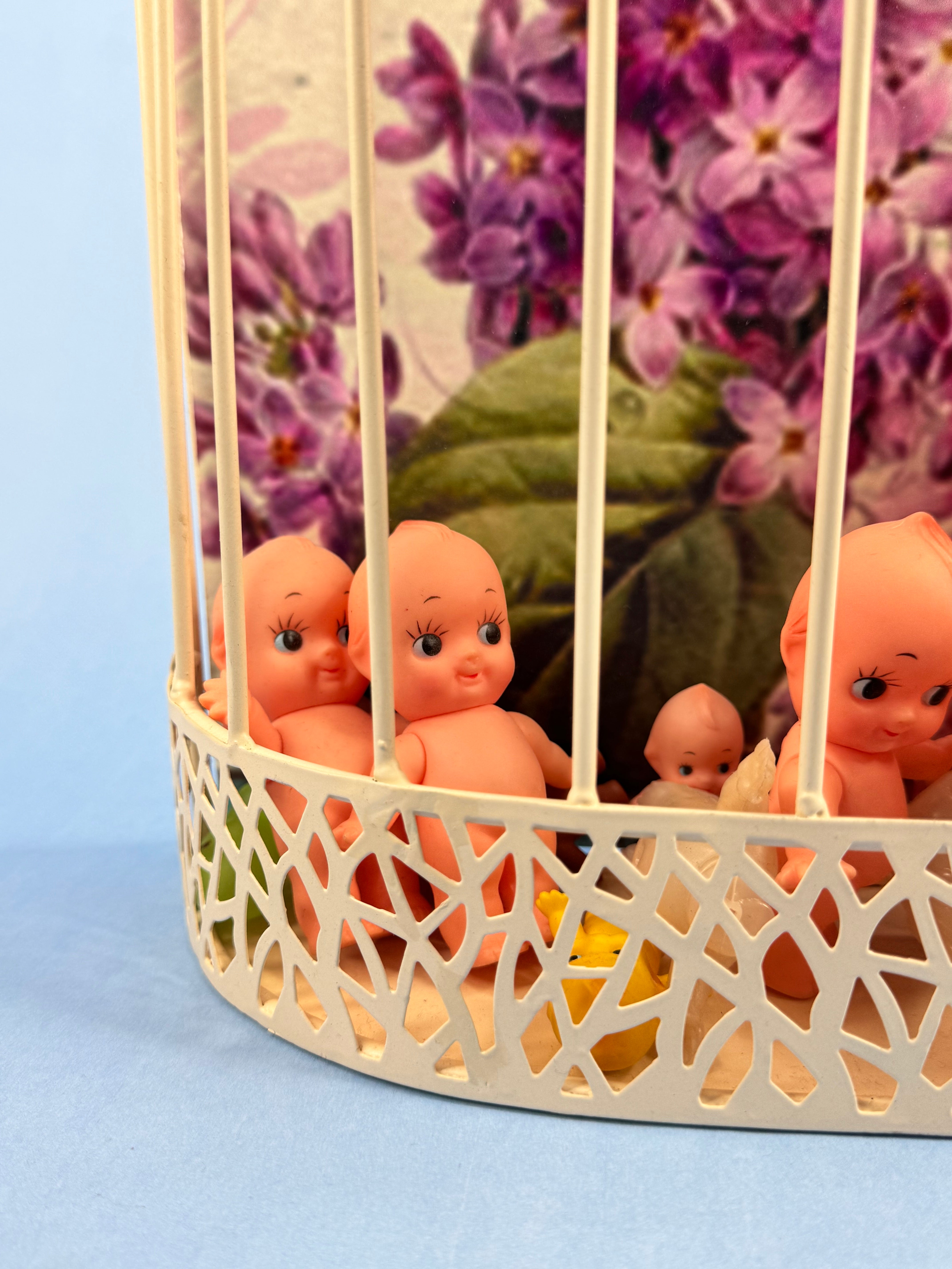 Cream Wall Mounted Bird Cage Inexplicably Filled with Kewpie Babies