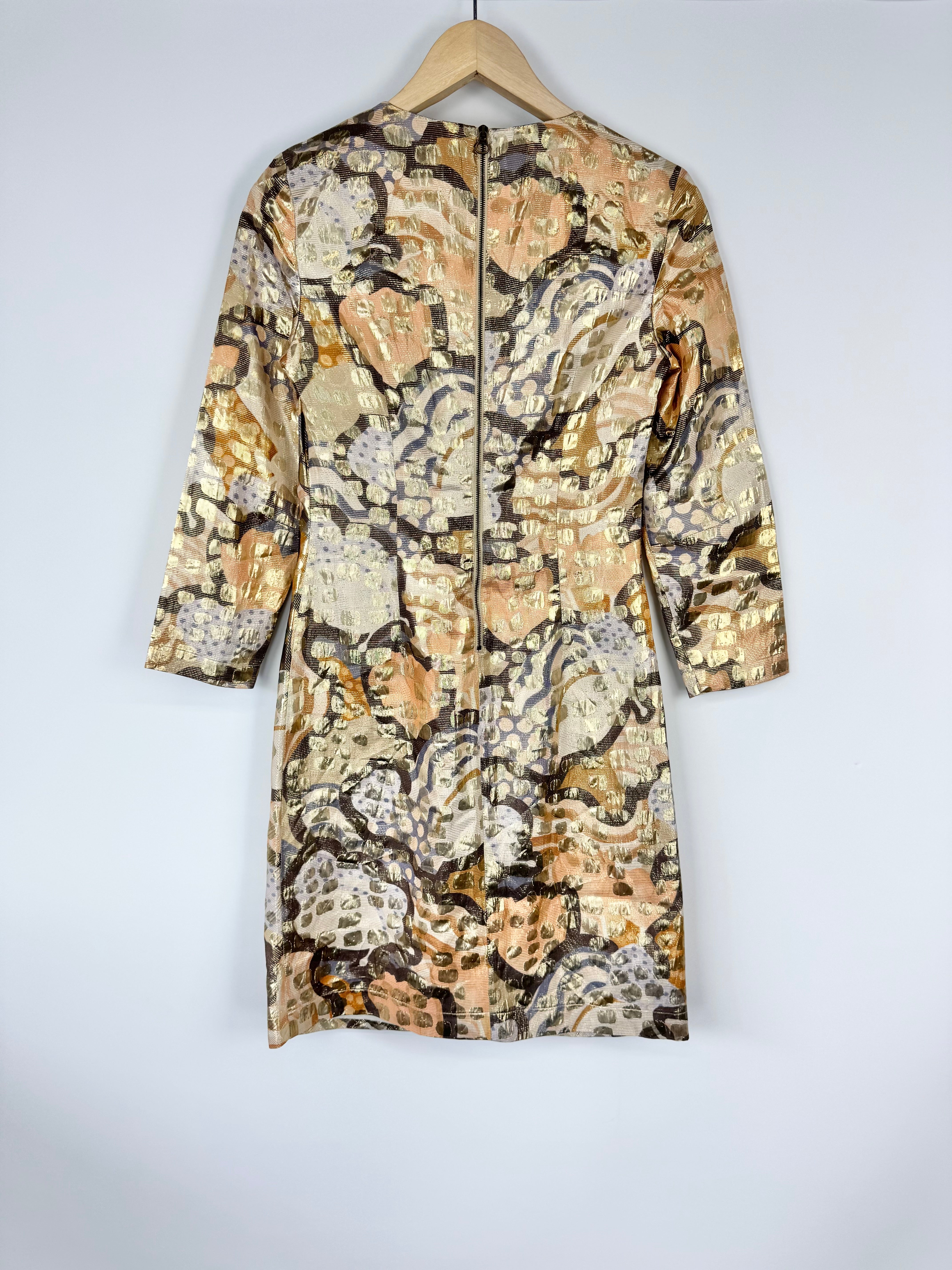 Floral patterned dress on a hanger against a white background