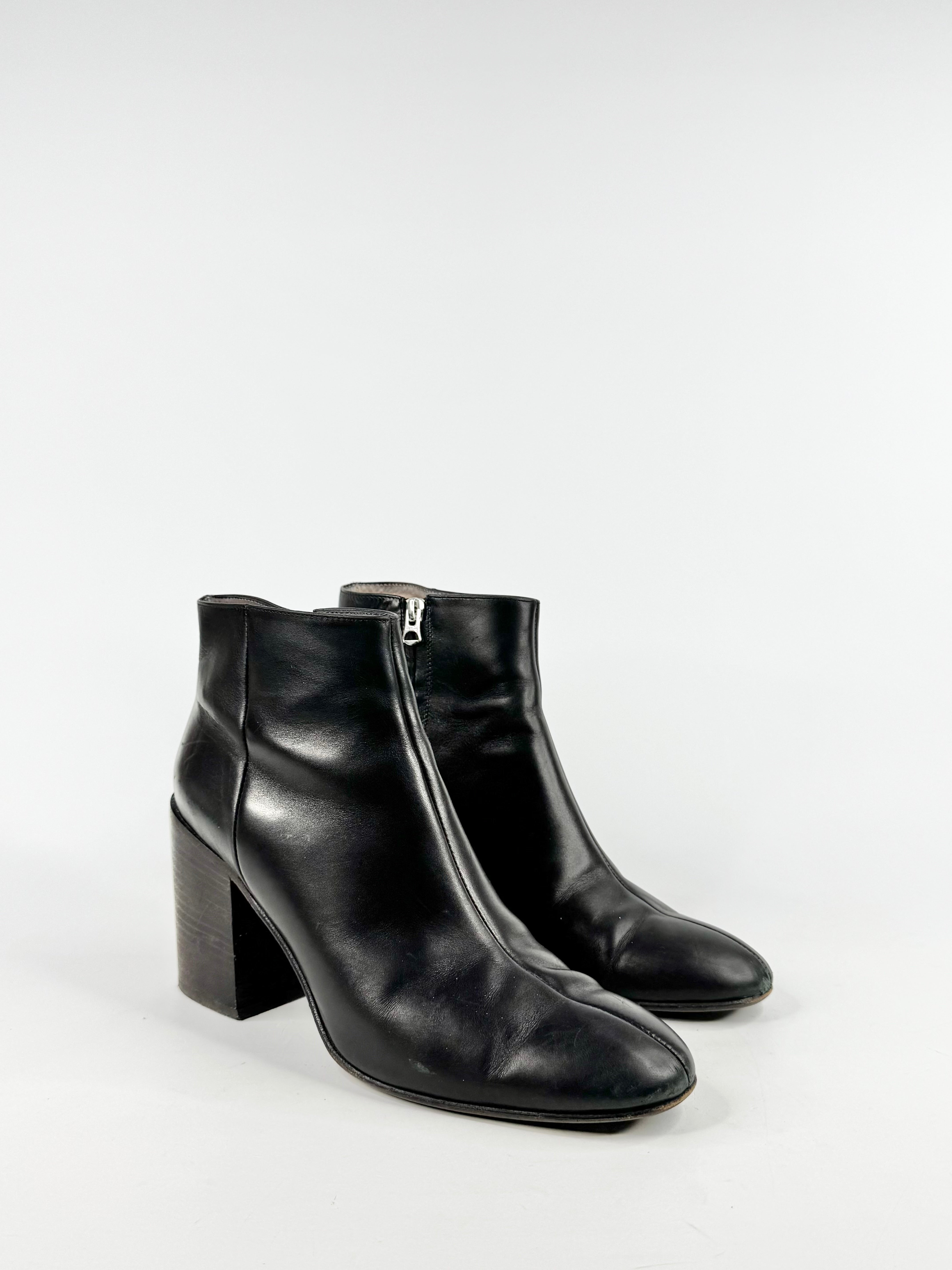 Black leather ankle boots with a block heel on a white background