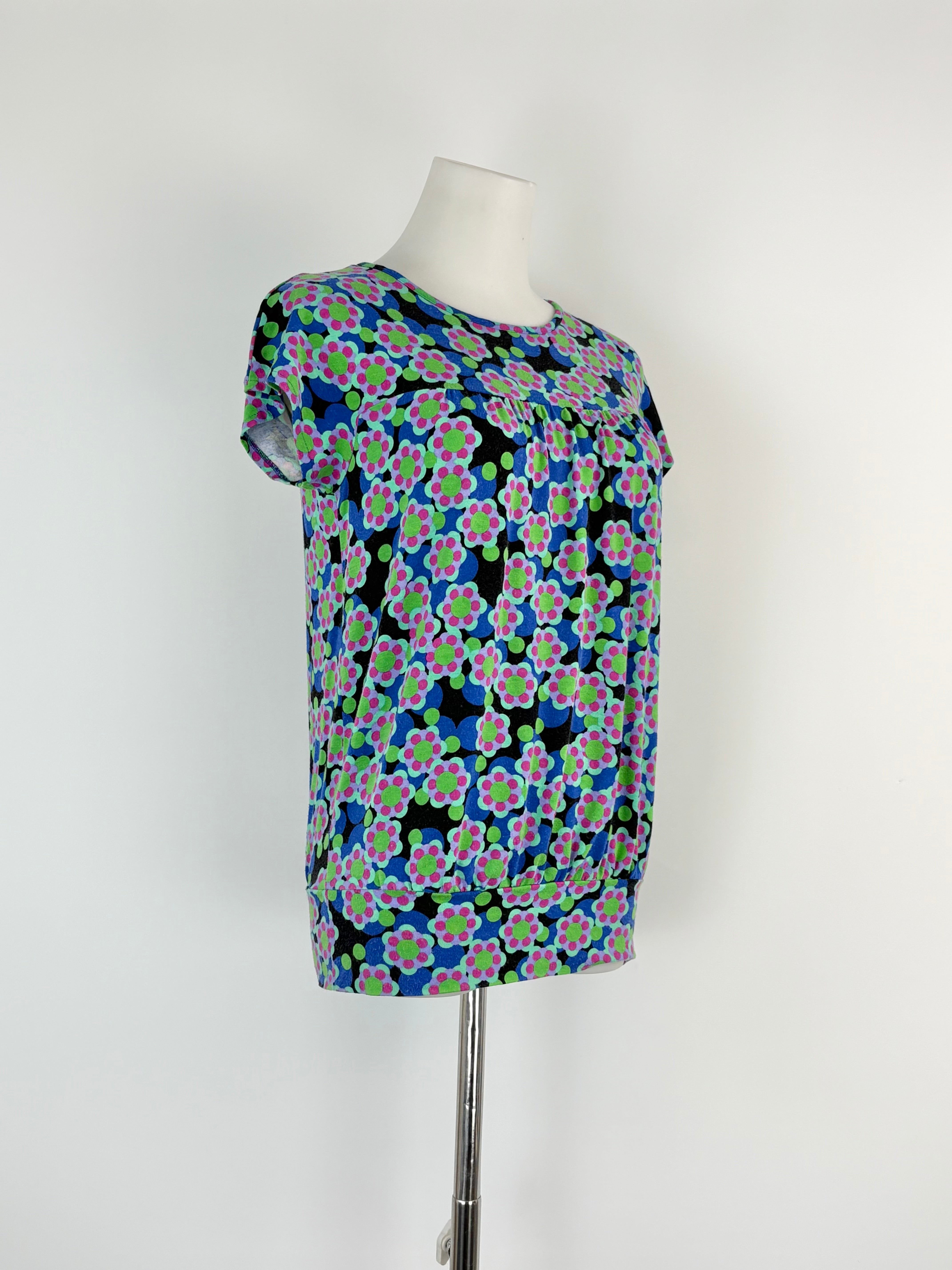 Floral patterned top on a mannequin against a white background
