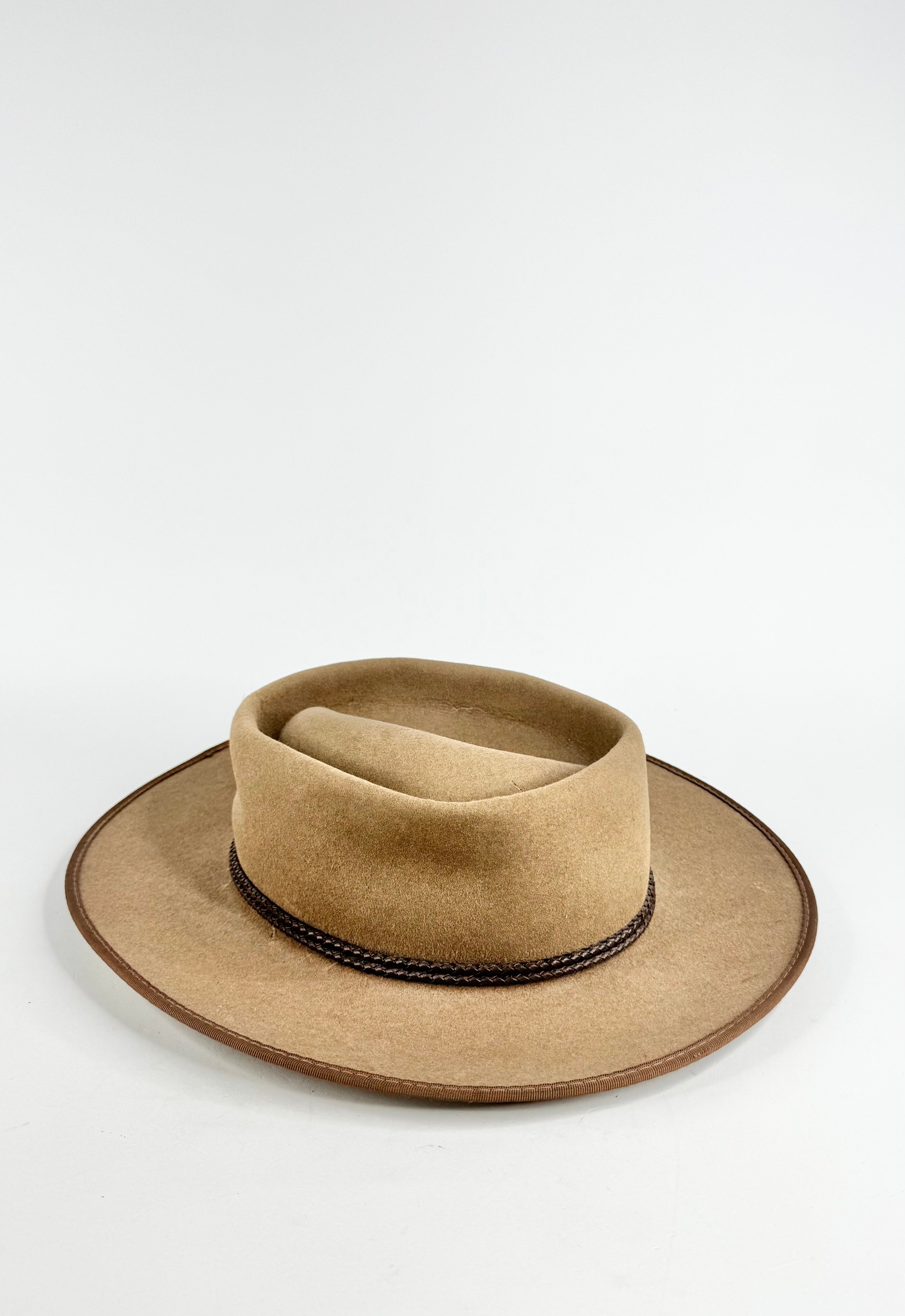 Beige hat with a black band on a white background