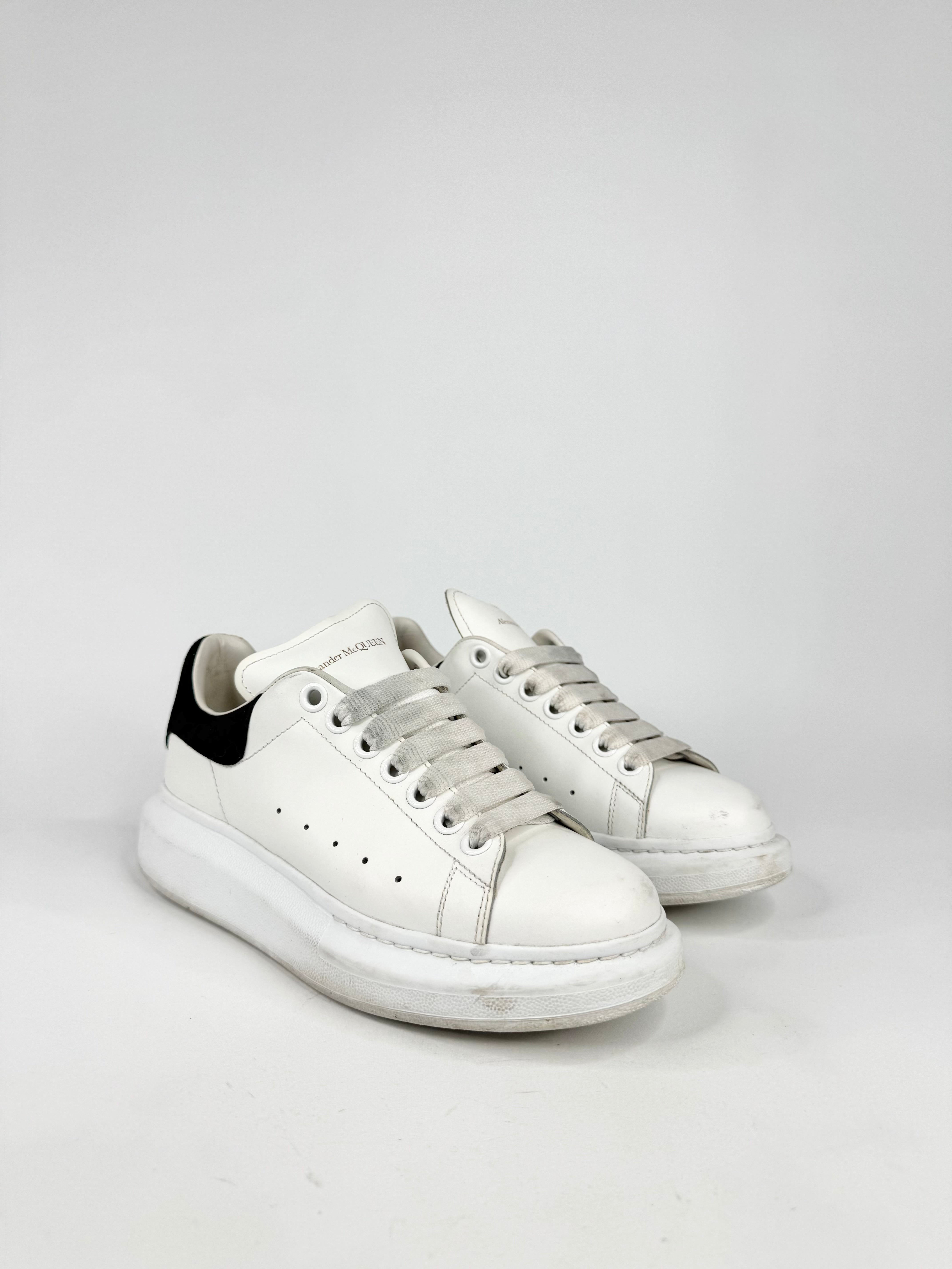 White sneakers with a black heel on a white background