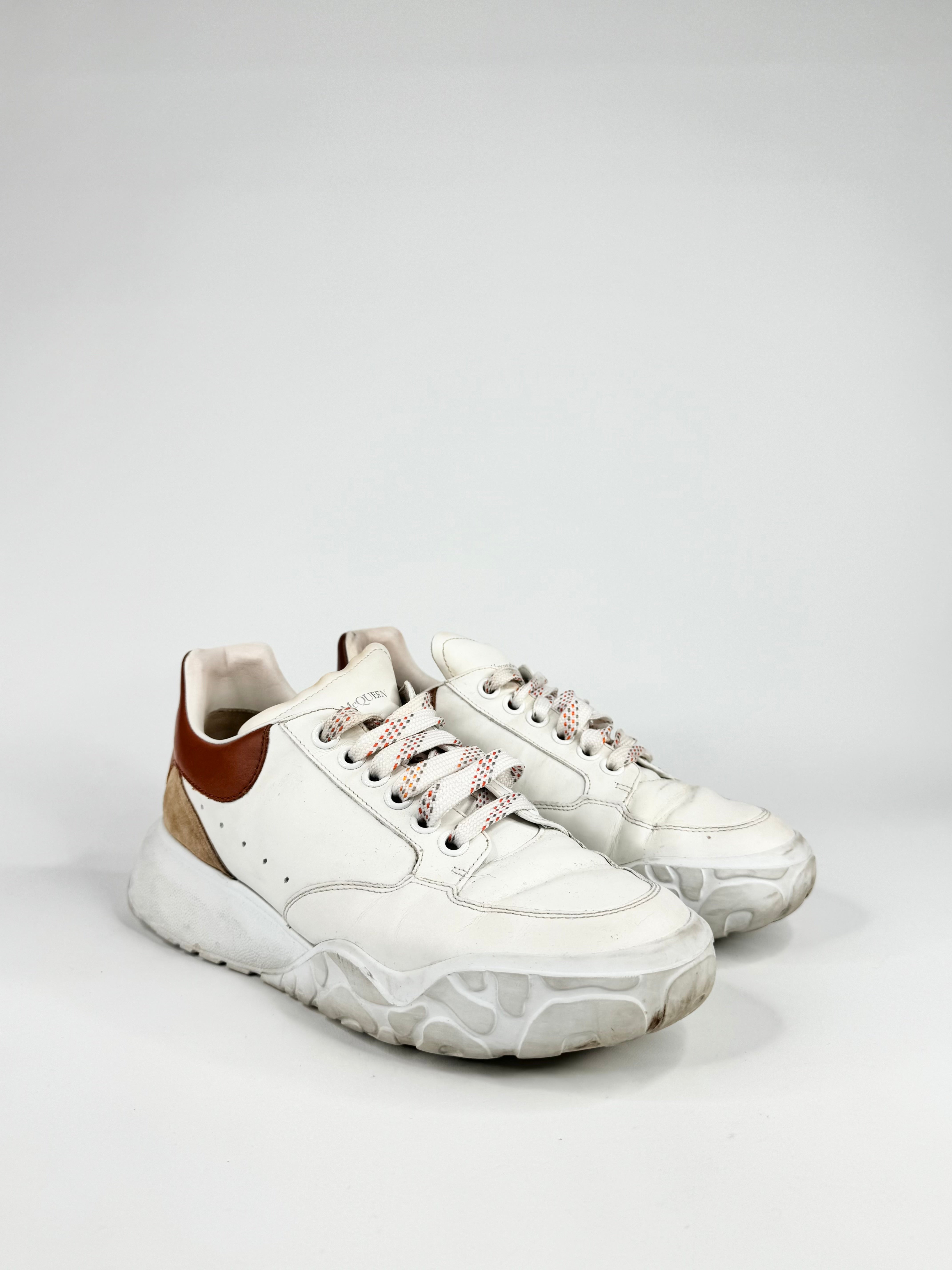 White sneakers with brown accents on a light gray background