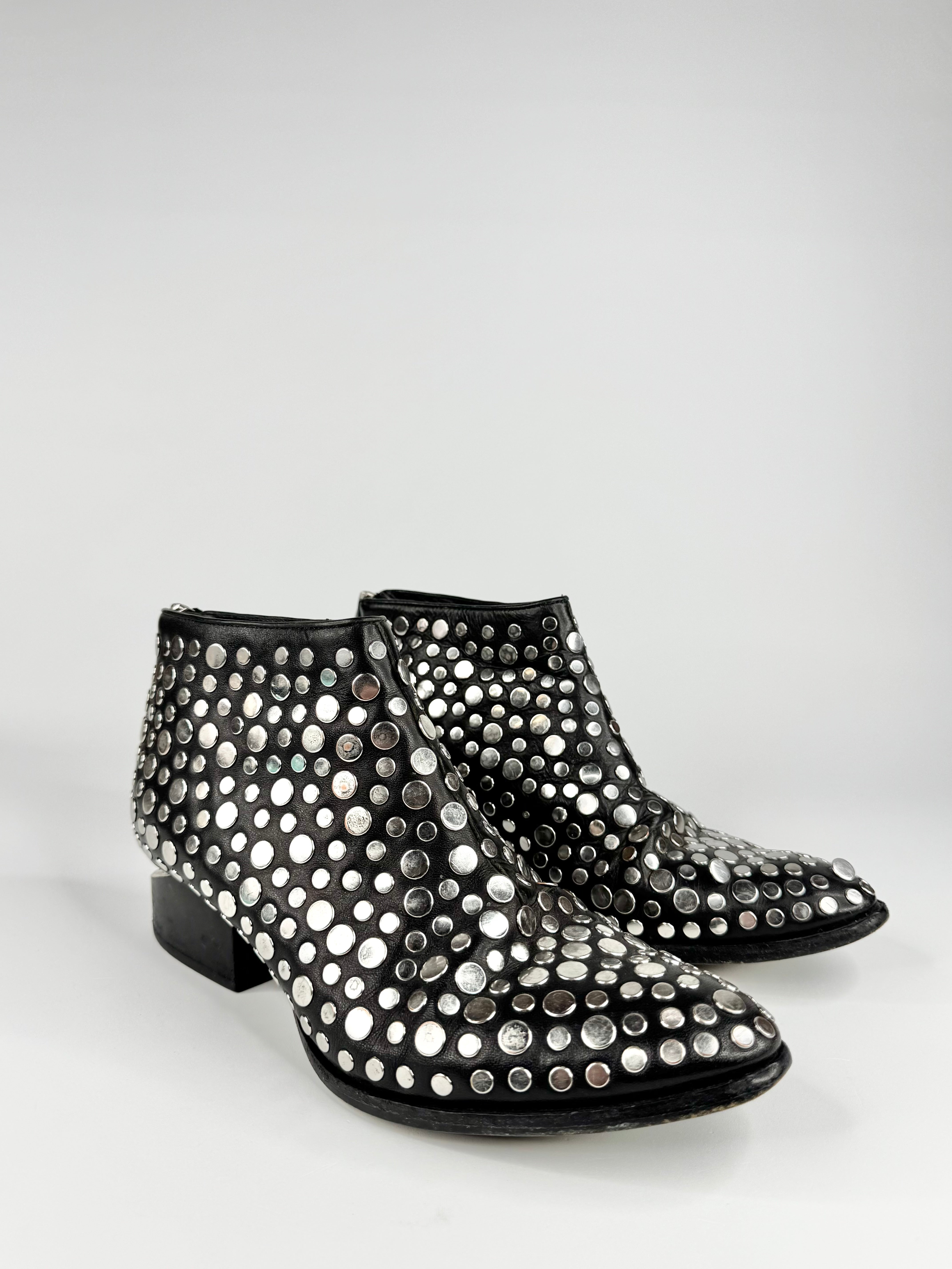 Black ankle boots with silver studs on a white background