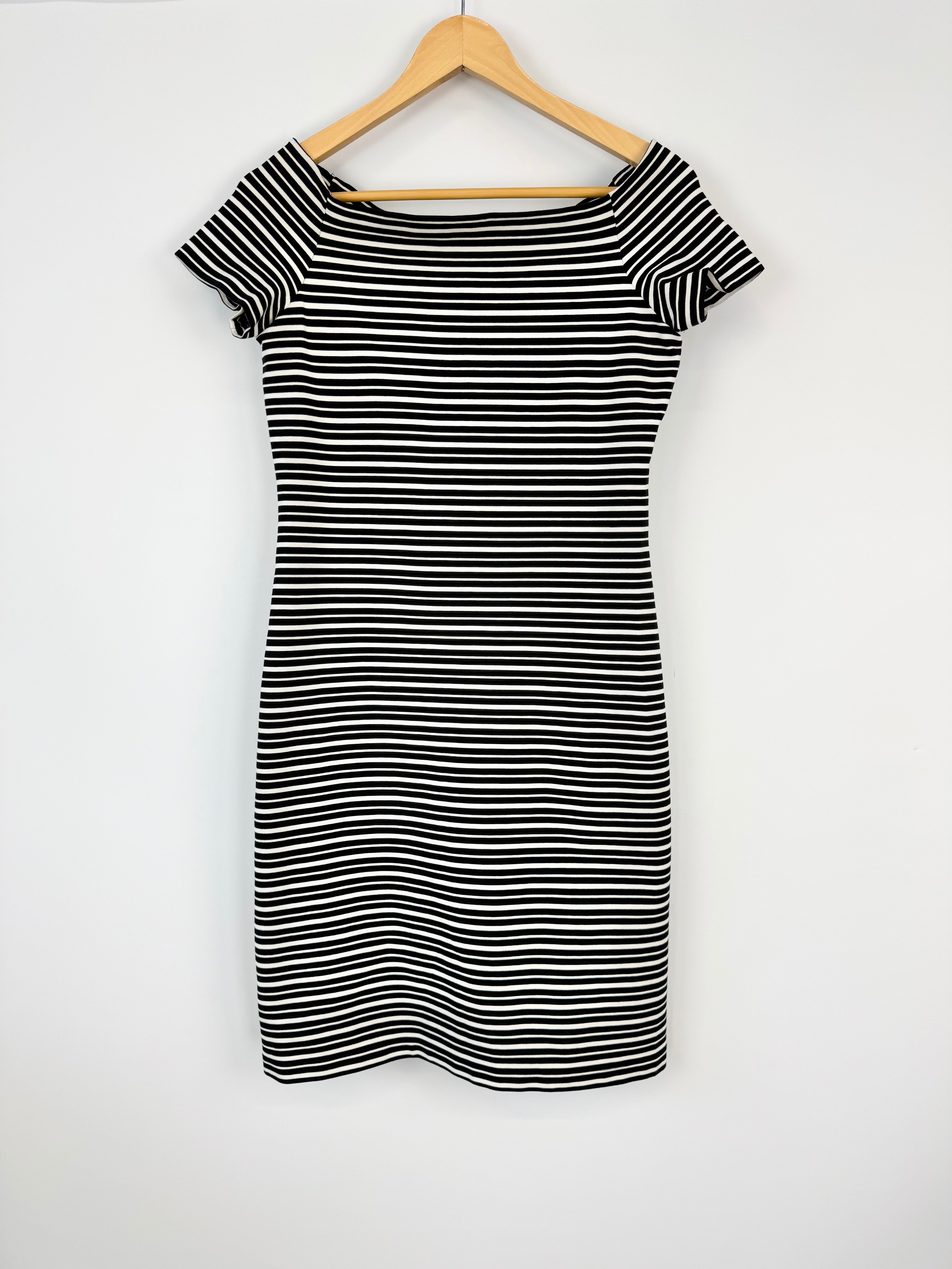 Black and white striped dress on a wooden hanger against a white background