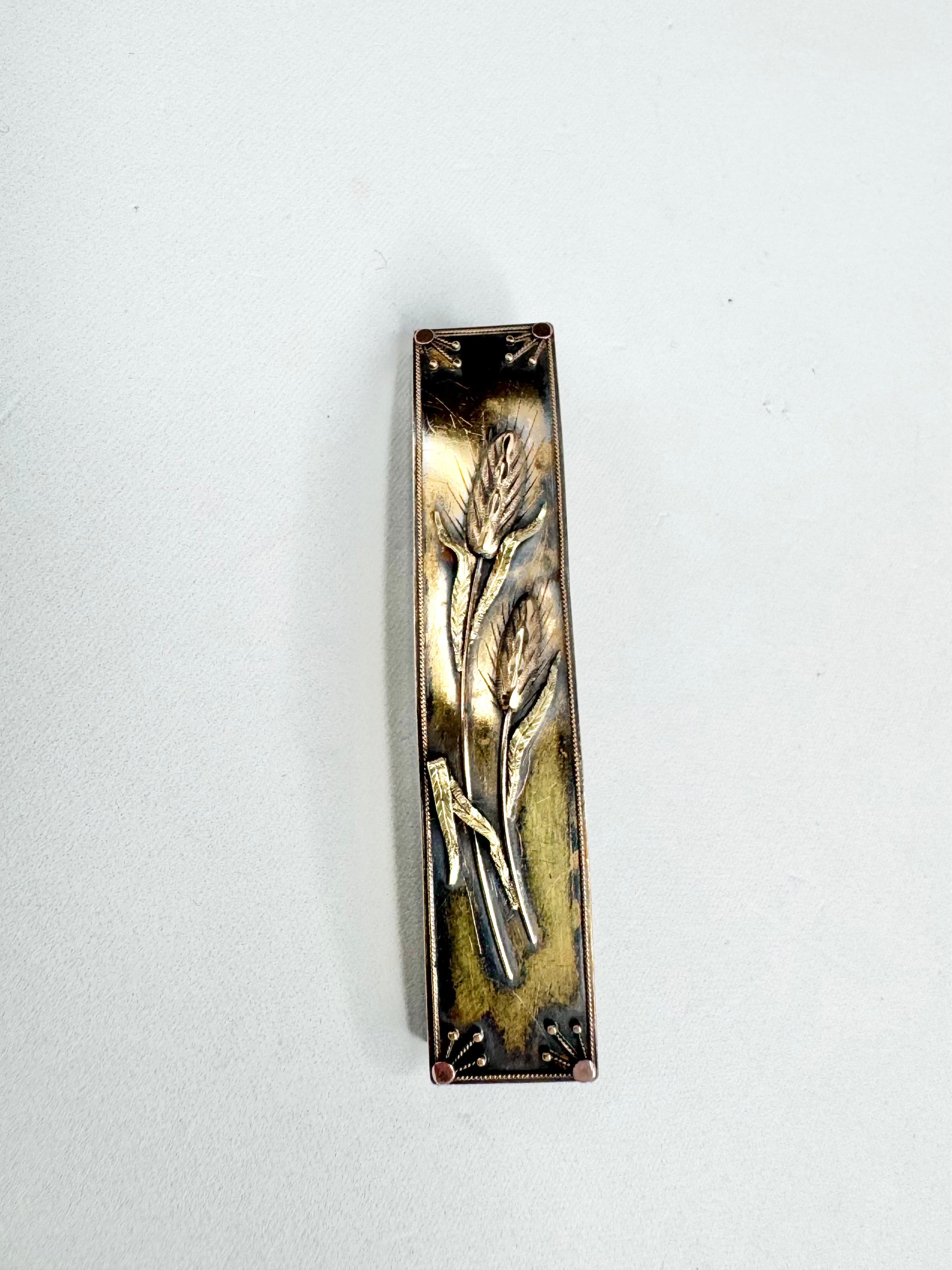 Decorative metal mezzuzah with floral design on a white background