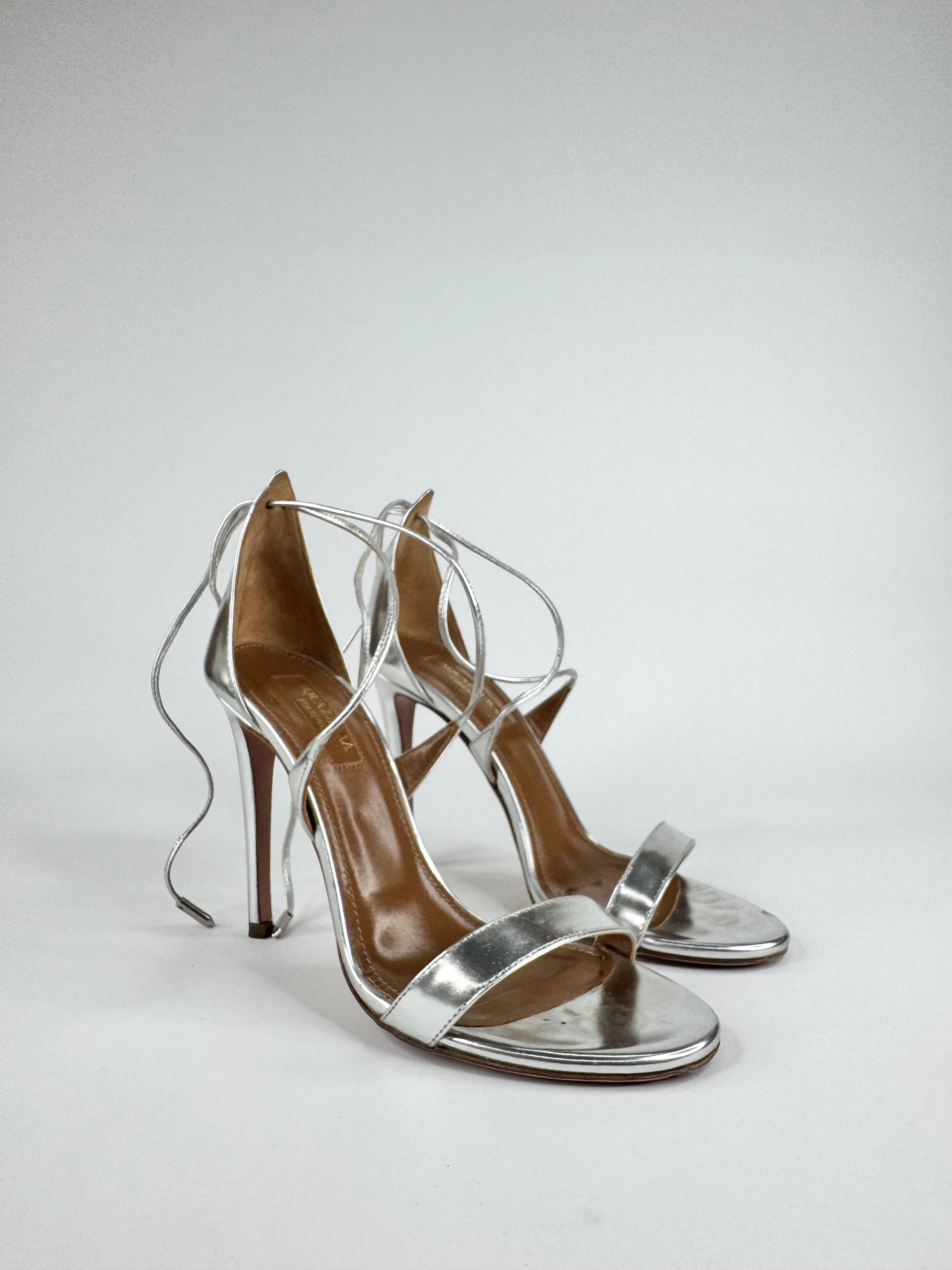 Silver high-heeled sandals on a white background