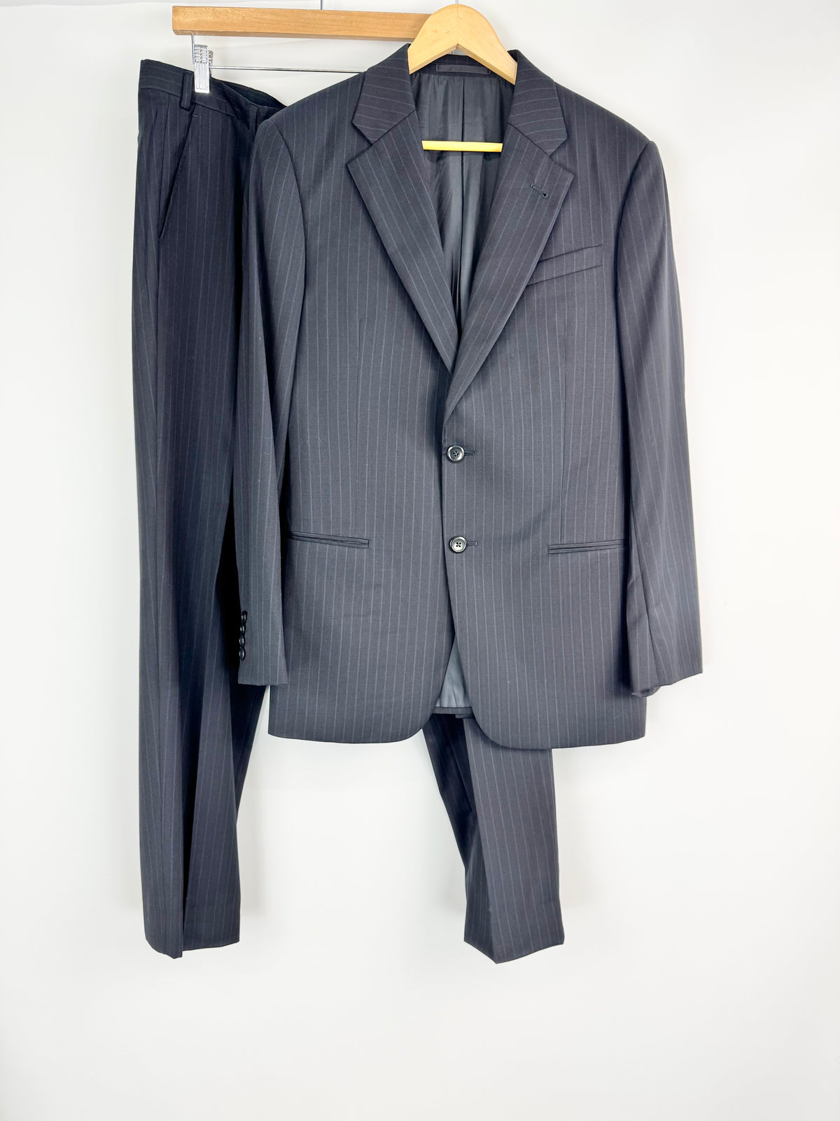 Gray pinstripe suit on a hanger against a white background