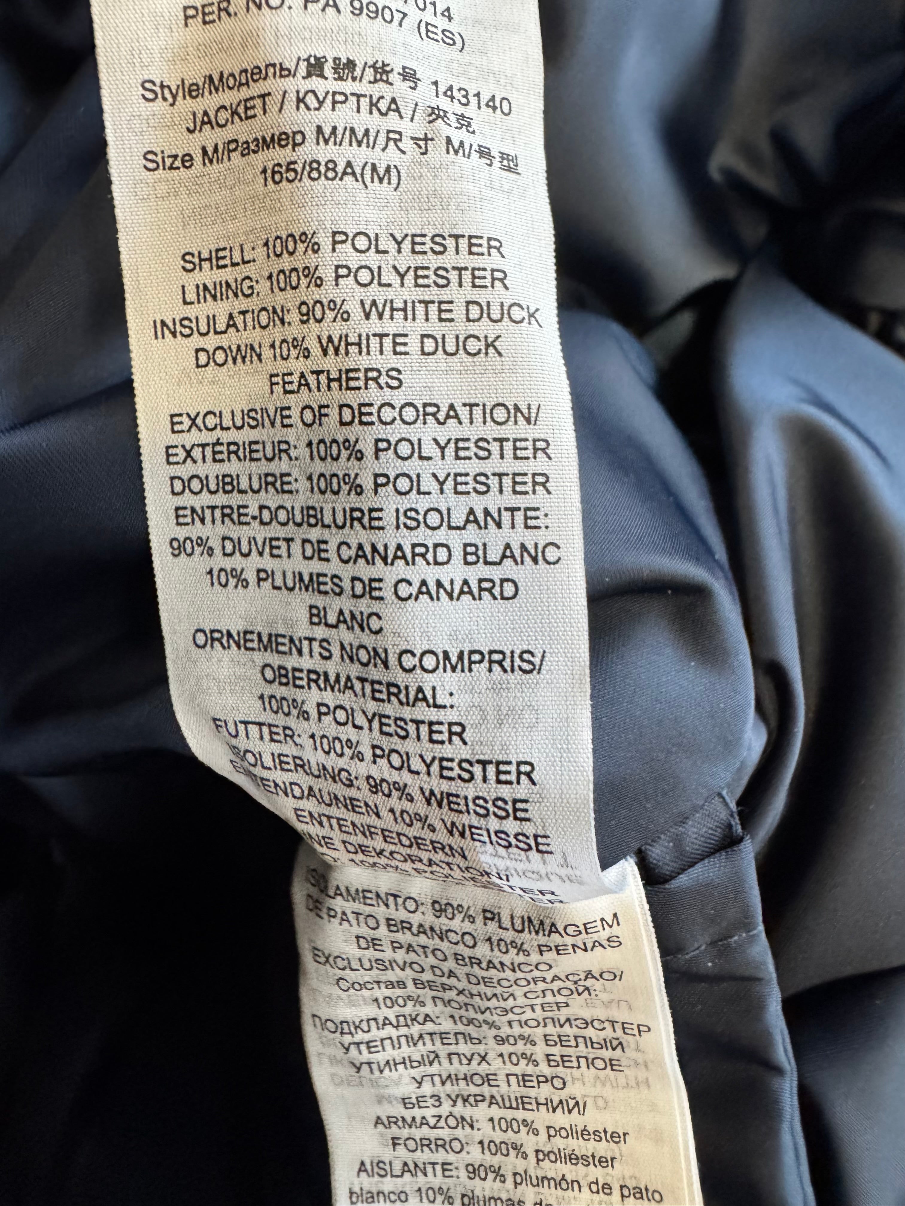 Close-up of a jacket label with text on a dark background