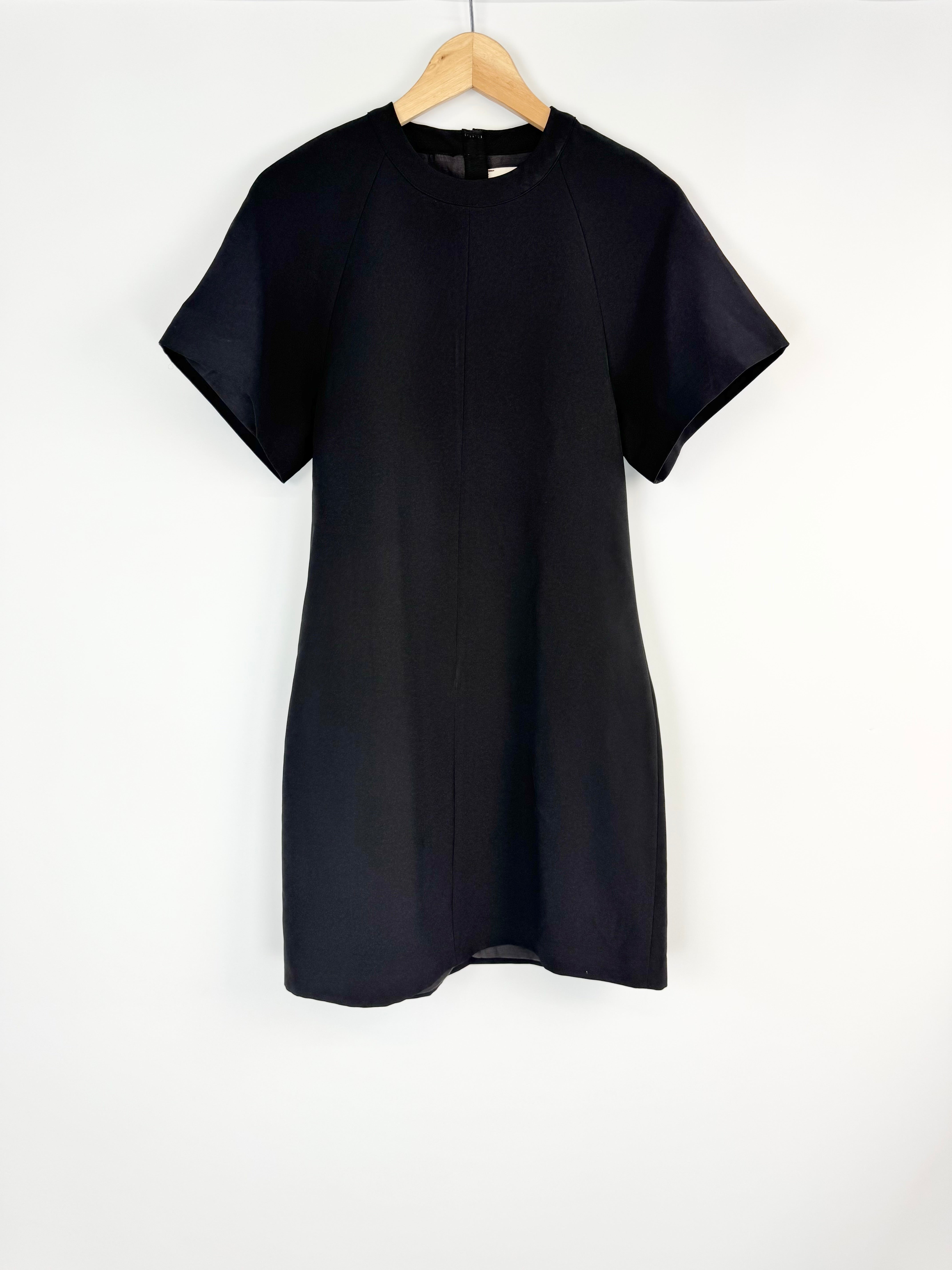 Black dress on a hanger against a white background