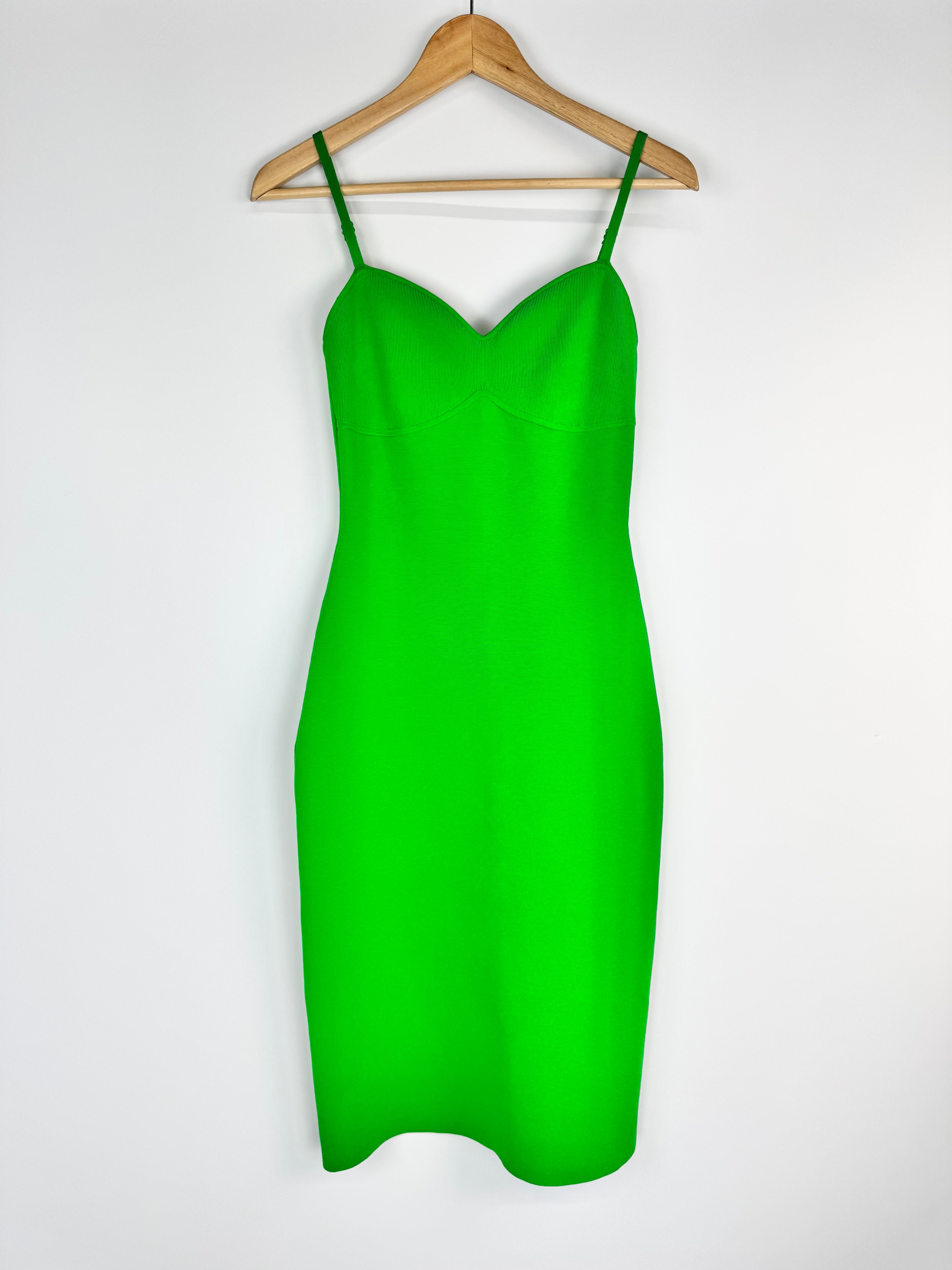 Green dress on a wooden hanger against a white background