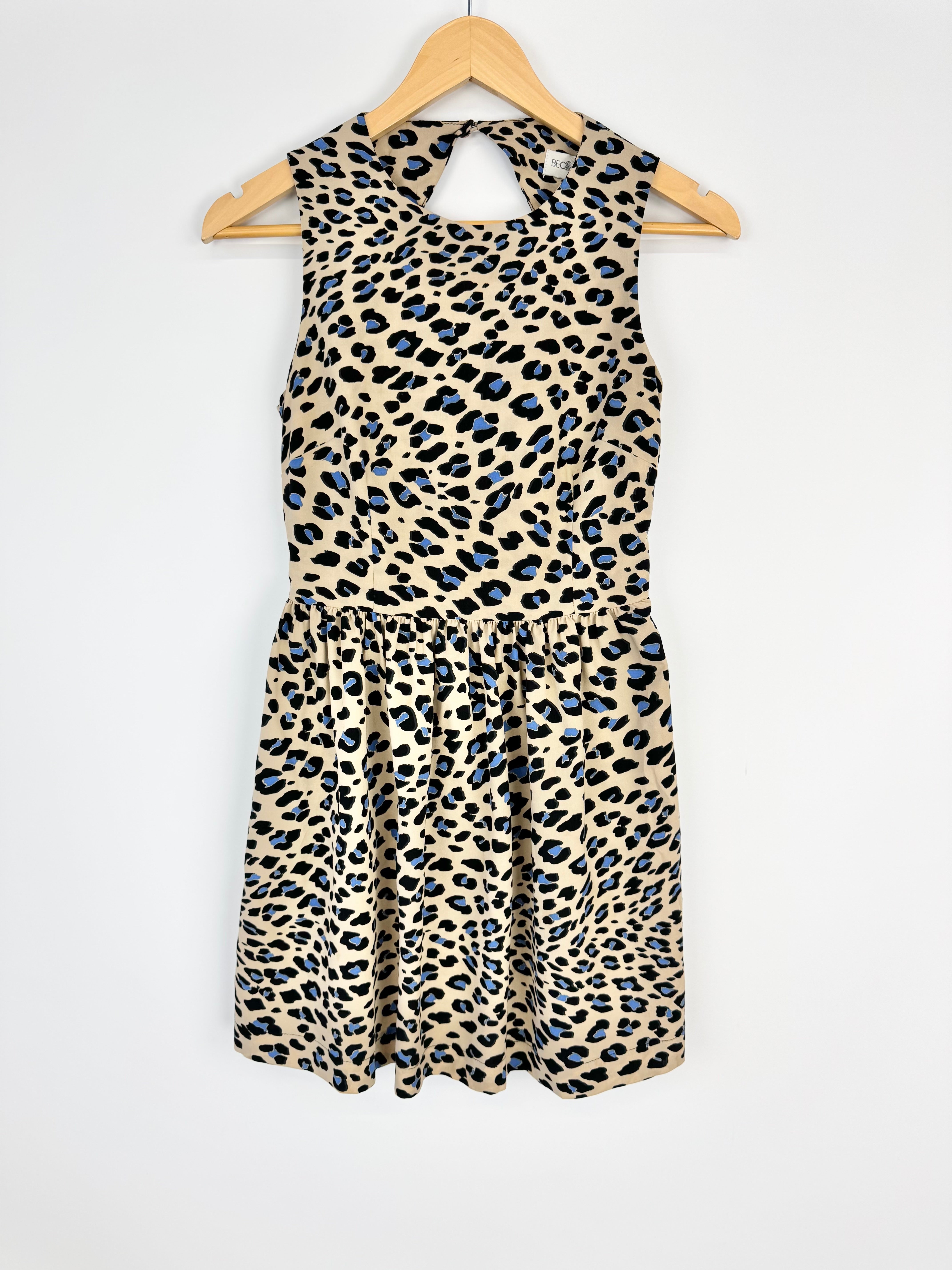 Leopard print dress on a hanger against a white background