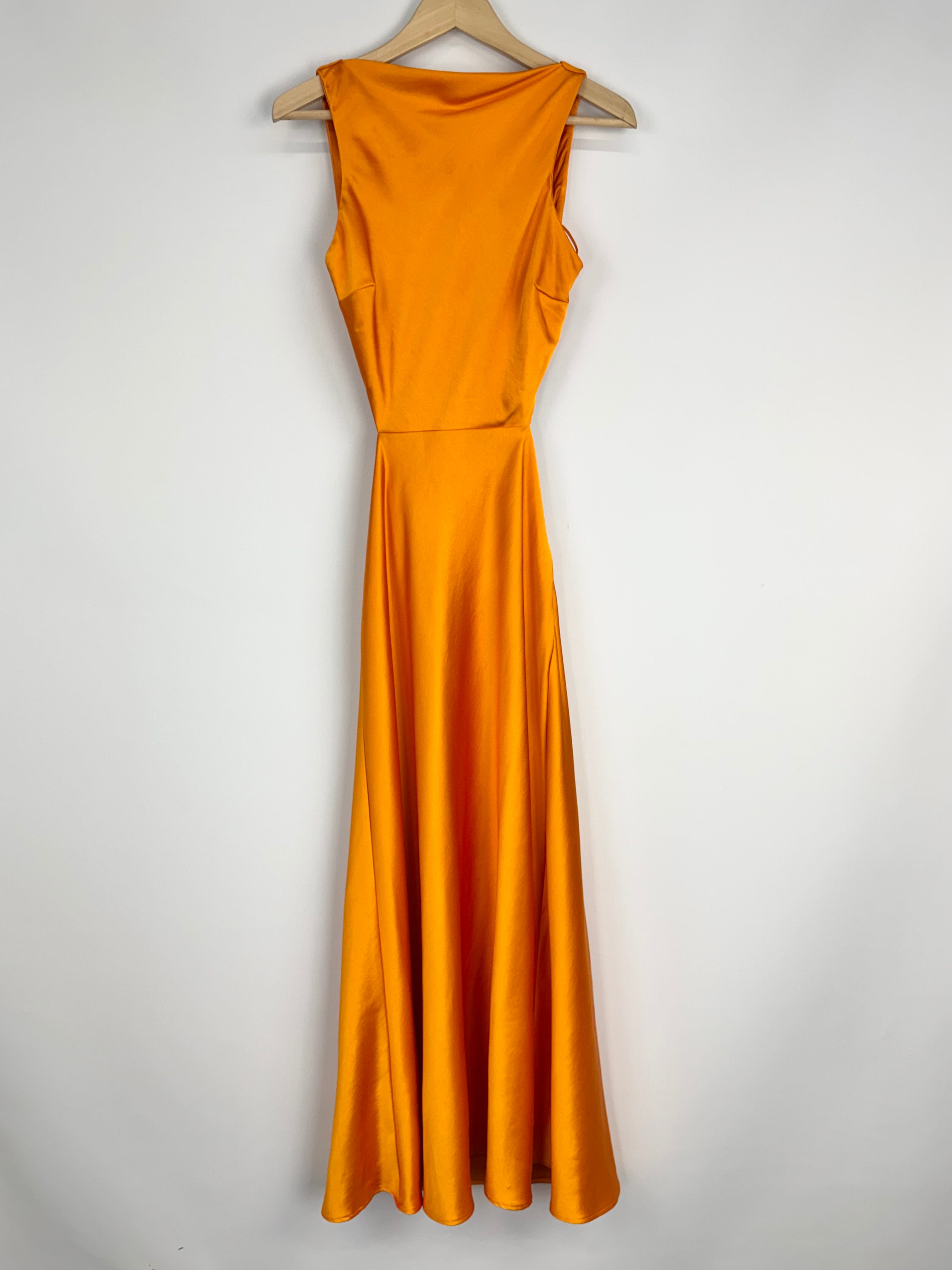 Mustard yellow evening gown on a hanger against a white background