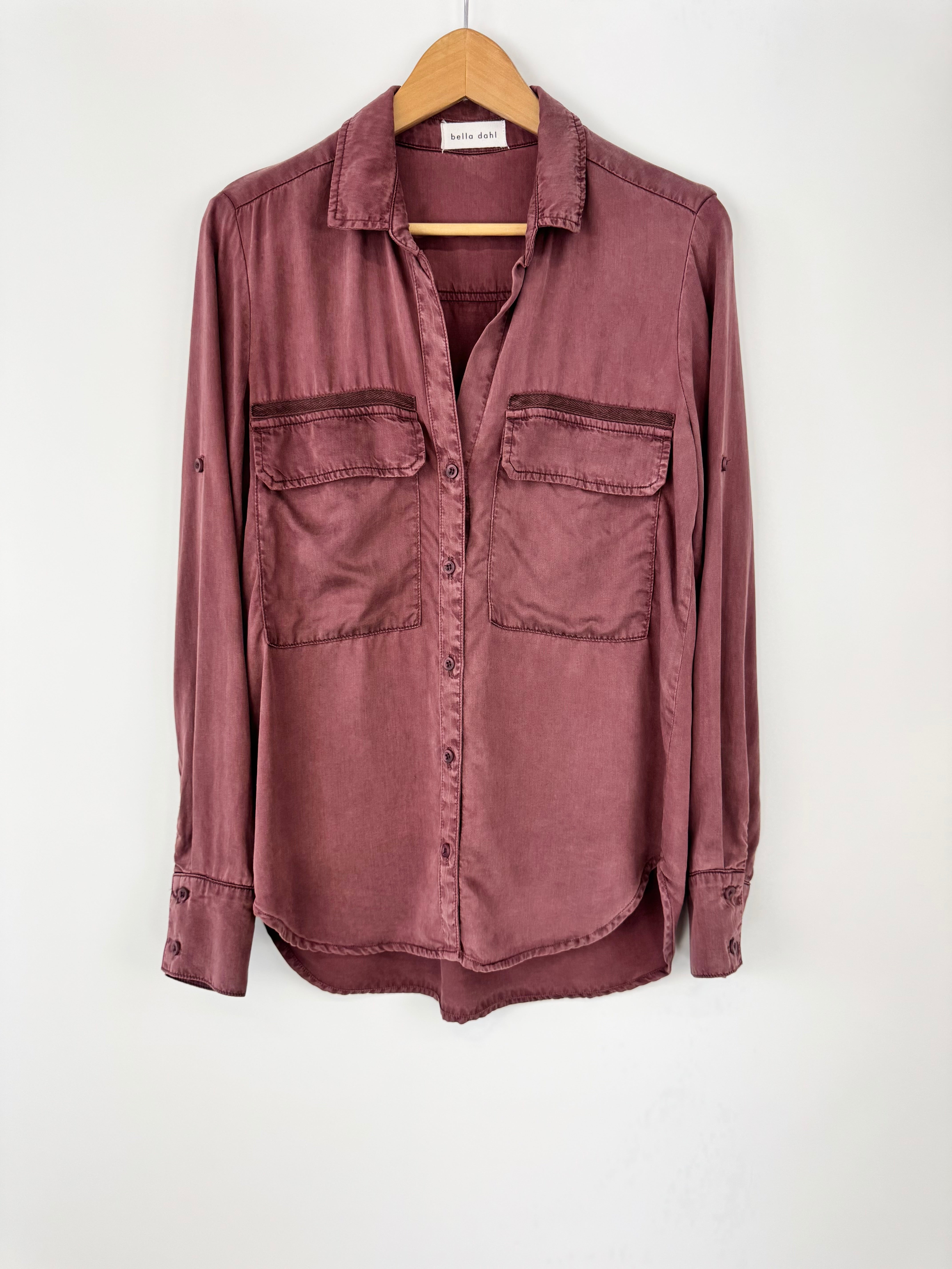 Maroon shirt on a hanger against a white background