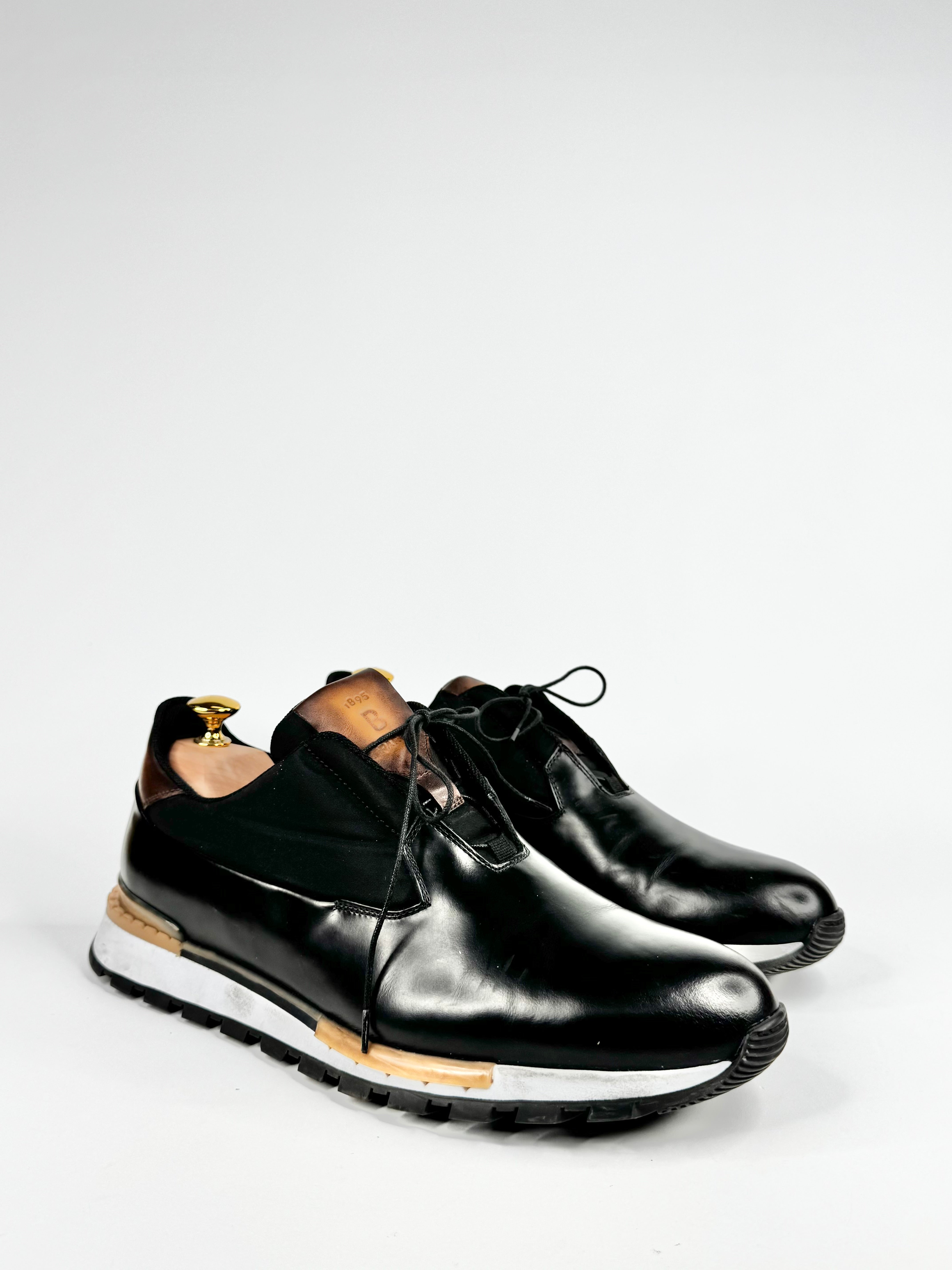 Black leather shoes with white soles on a light gray background