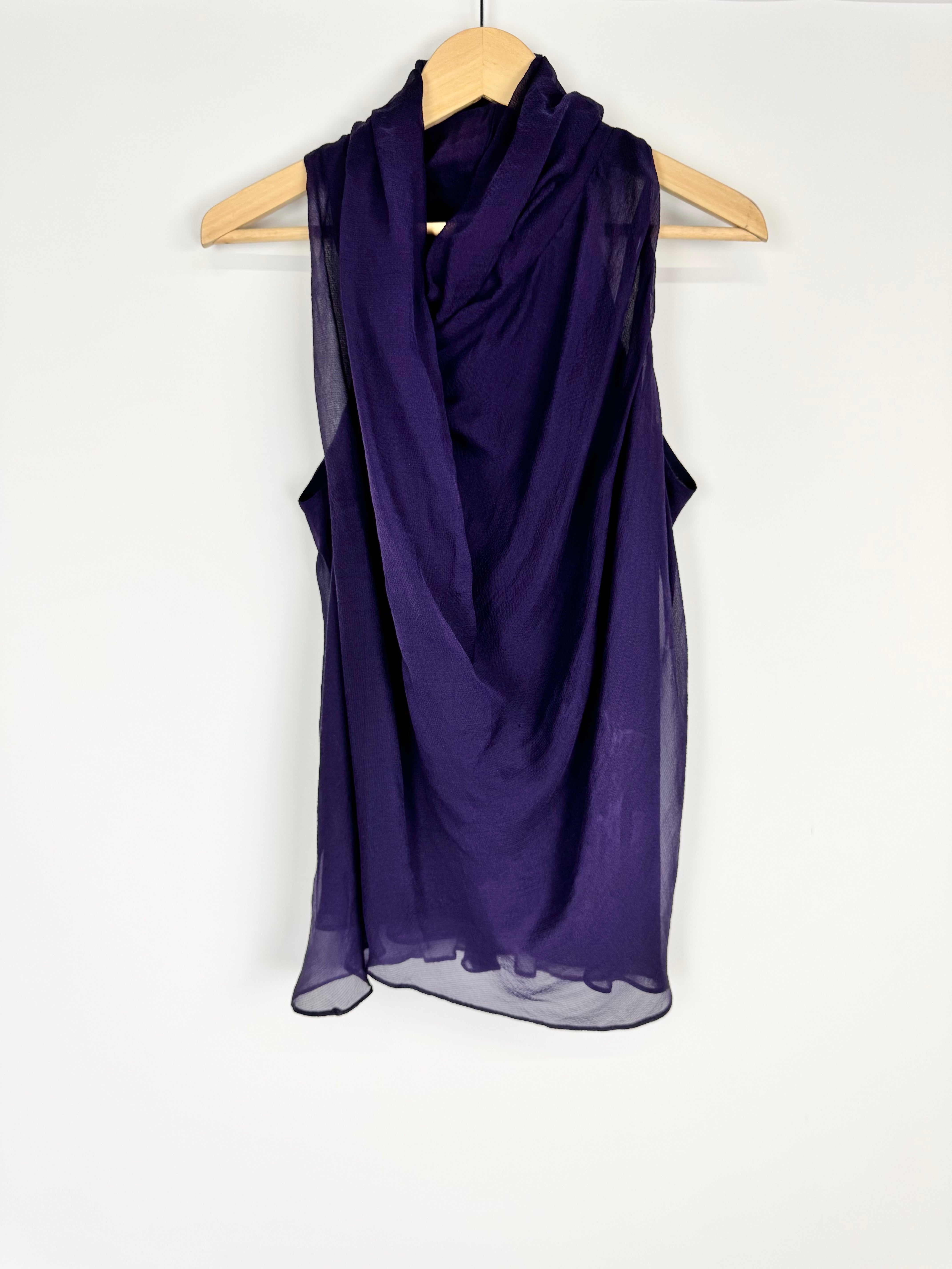Purple scarf draped over a wooden hanger on a white background