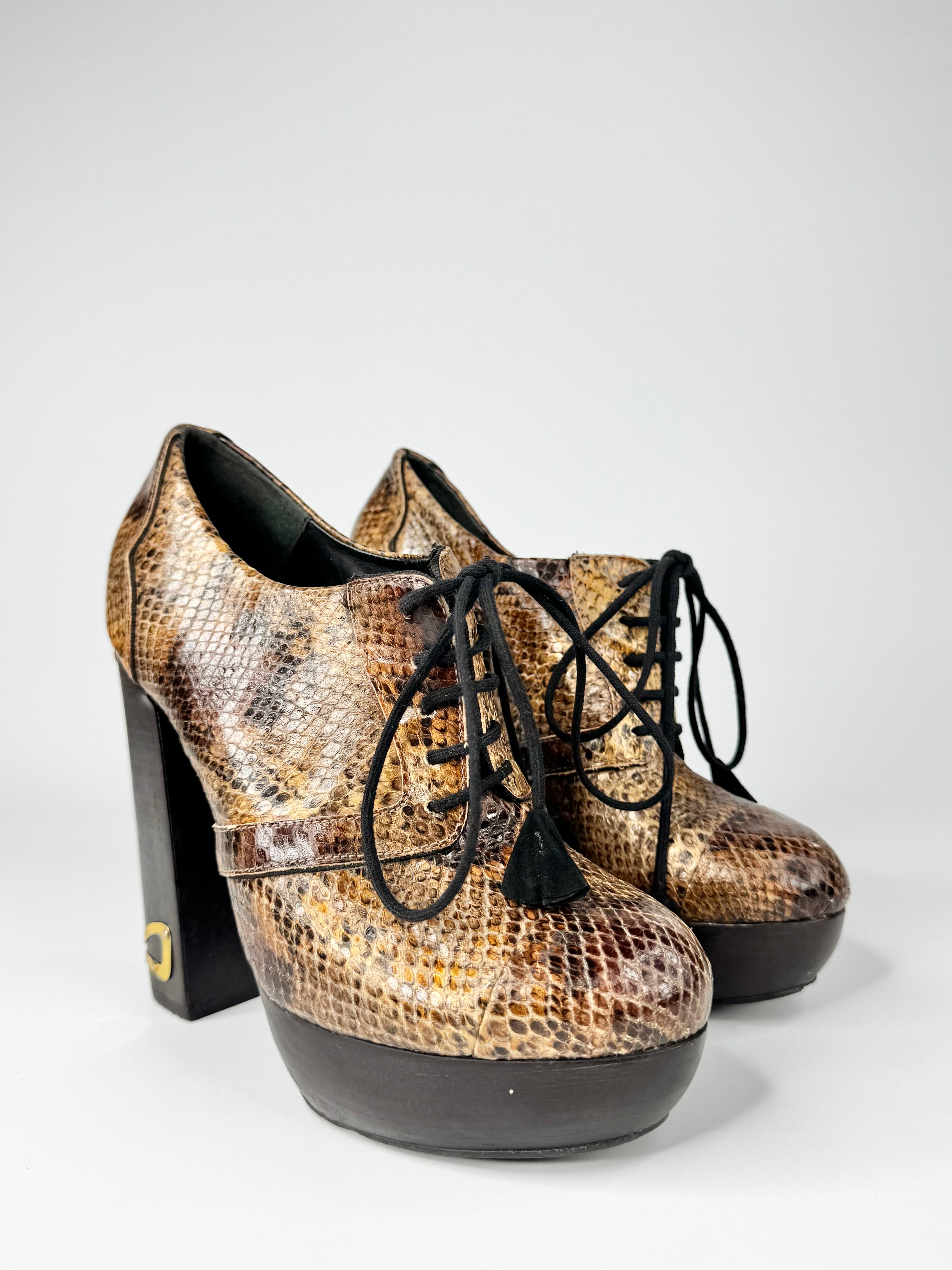 Pair of snakeskin-patterned high-heeled shoes on a white background