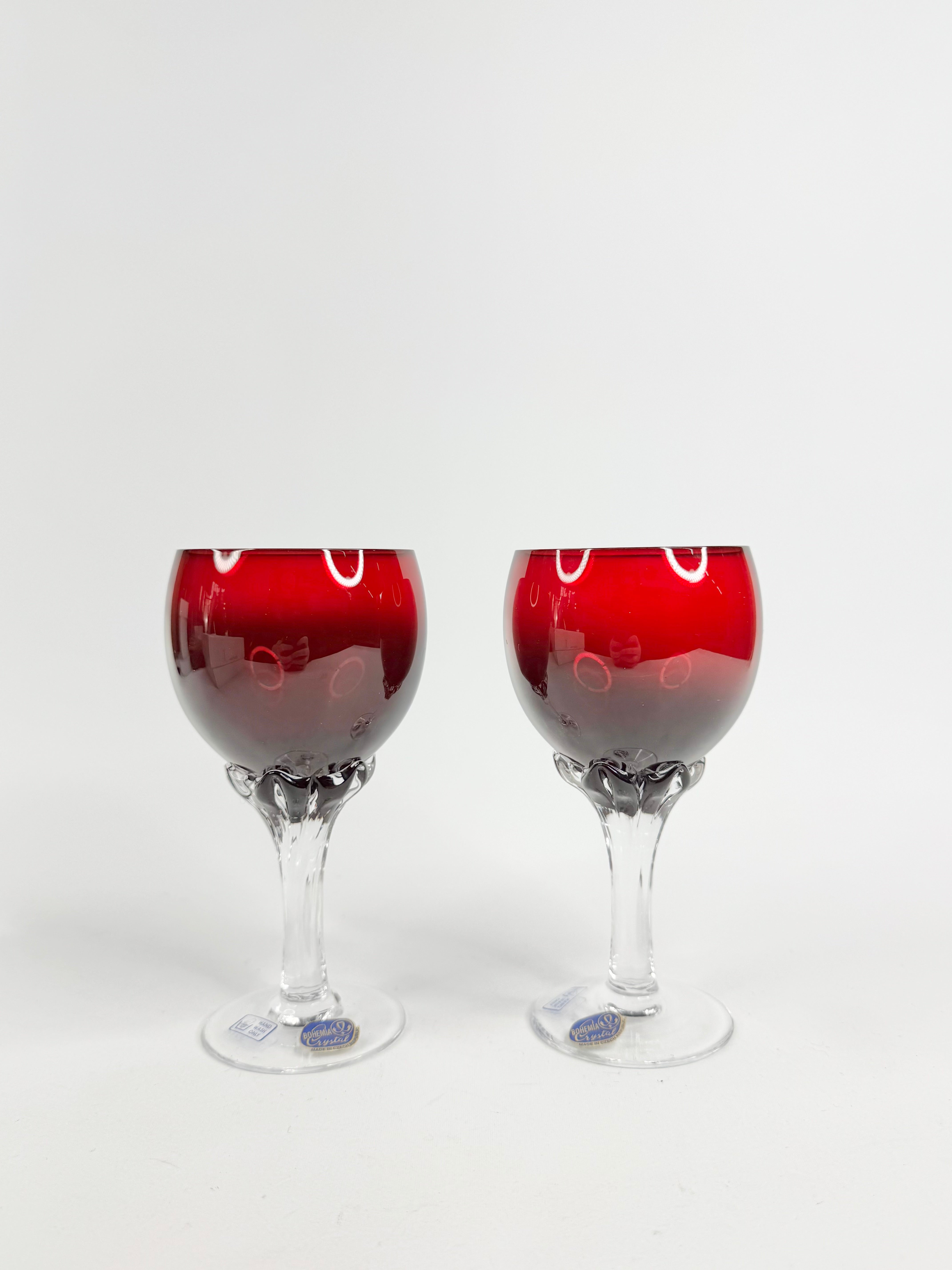 Two wine glasses with red liquid on a white background