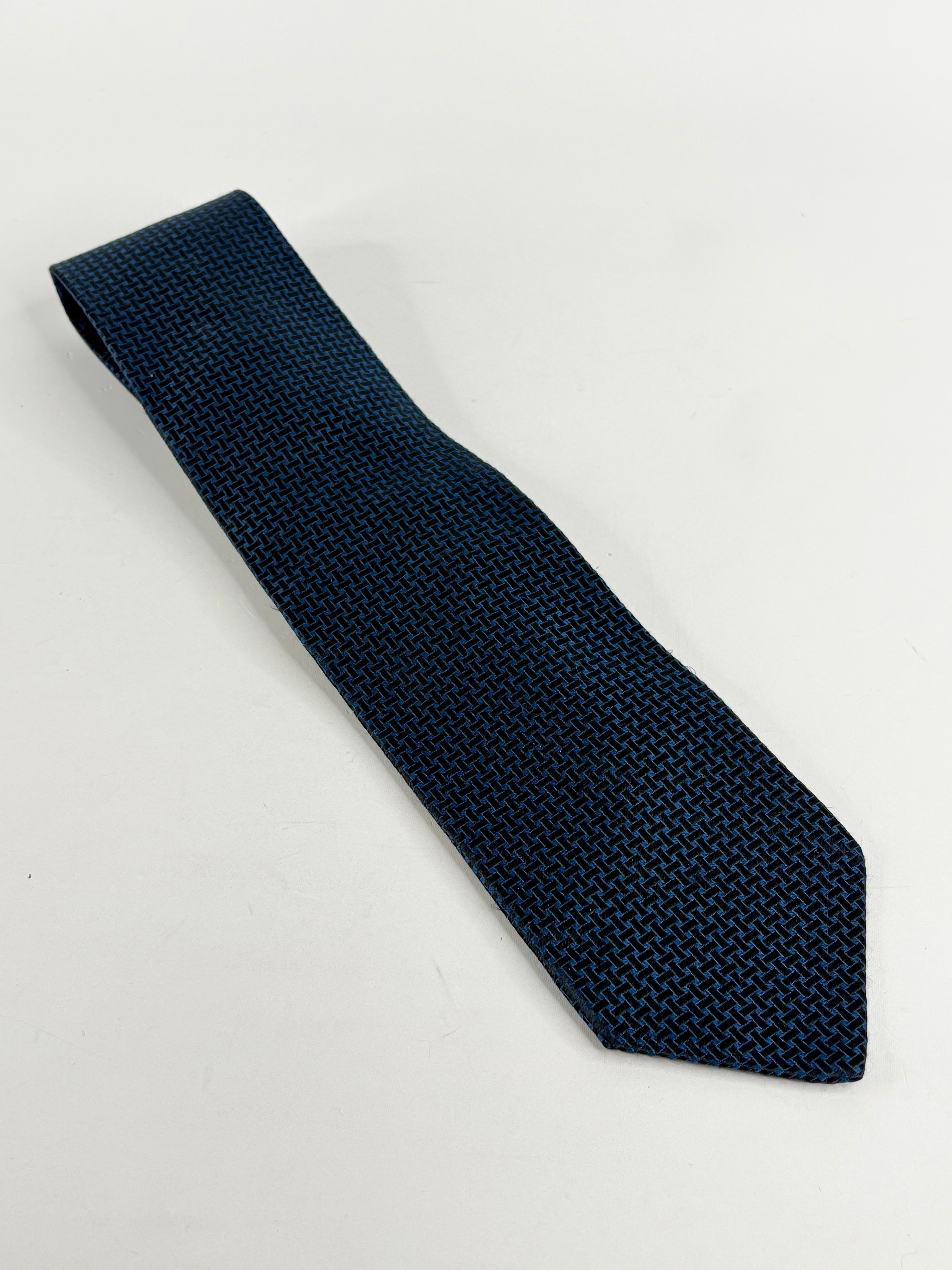 A midnight blue and black criss-cross pattern silk tie by Boss Hugo Boss laid out on a white background.