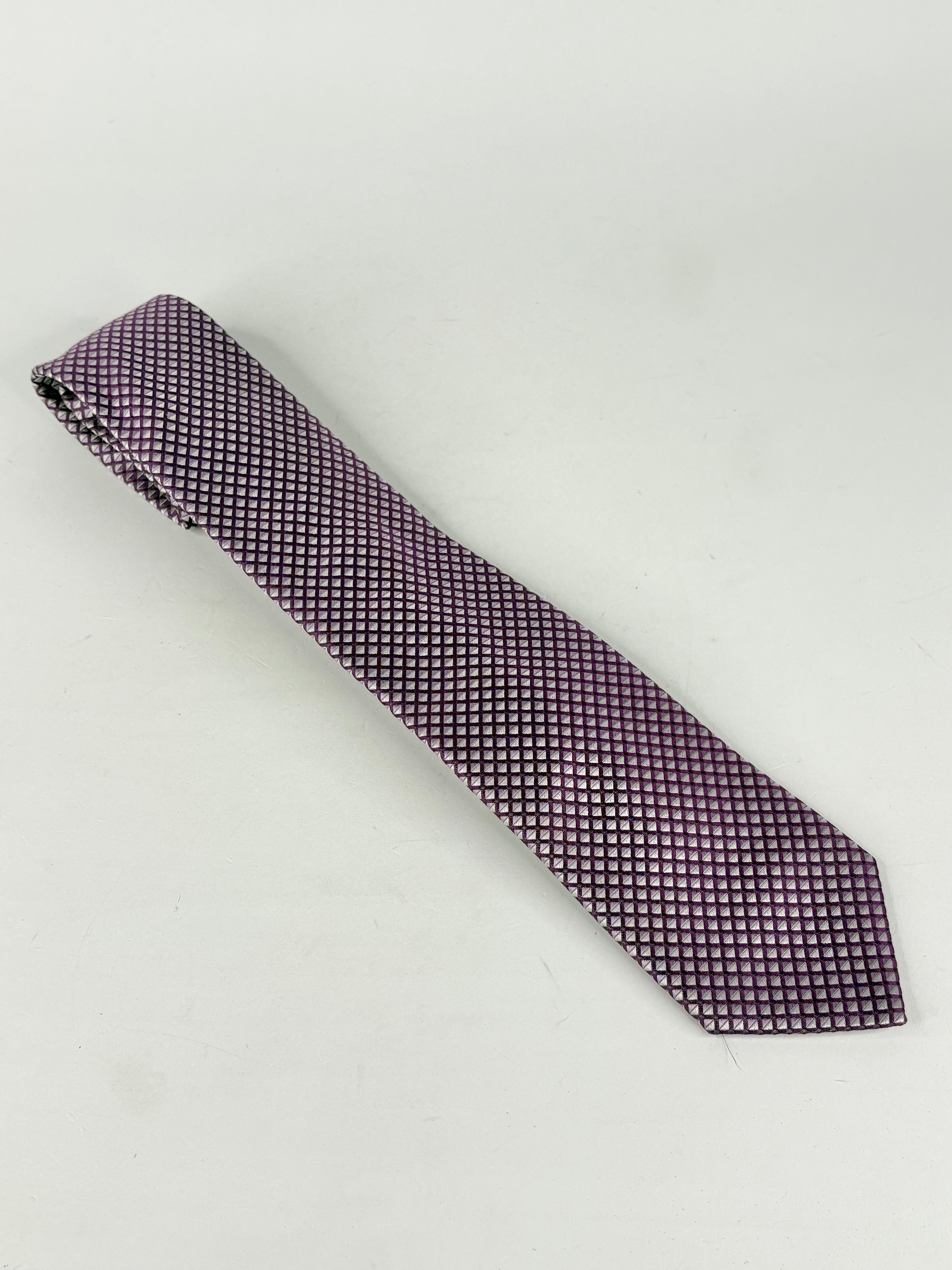 Purple patterned tie on a light gray background