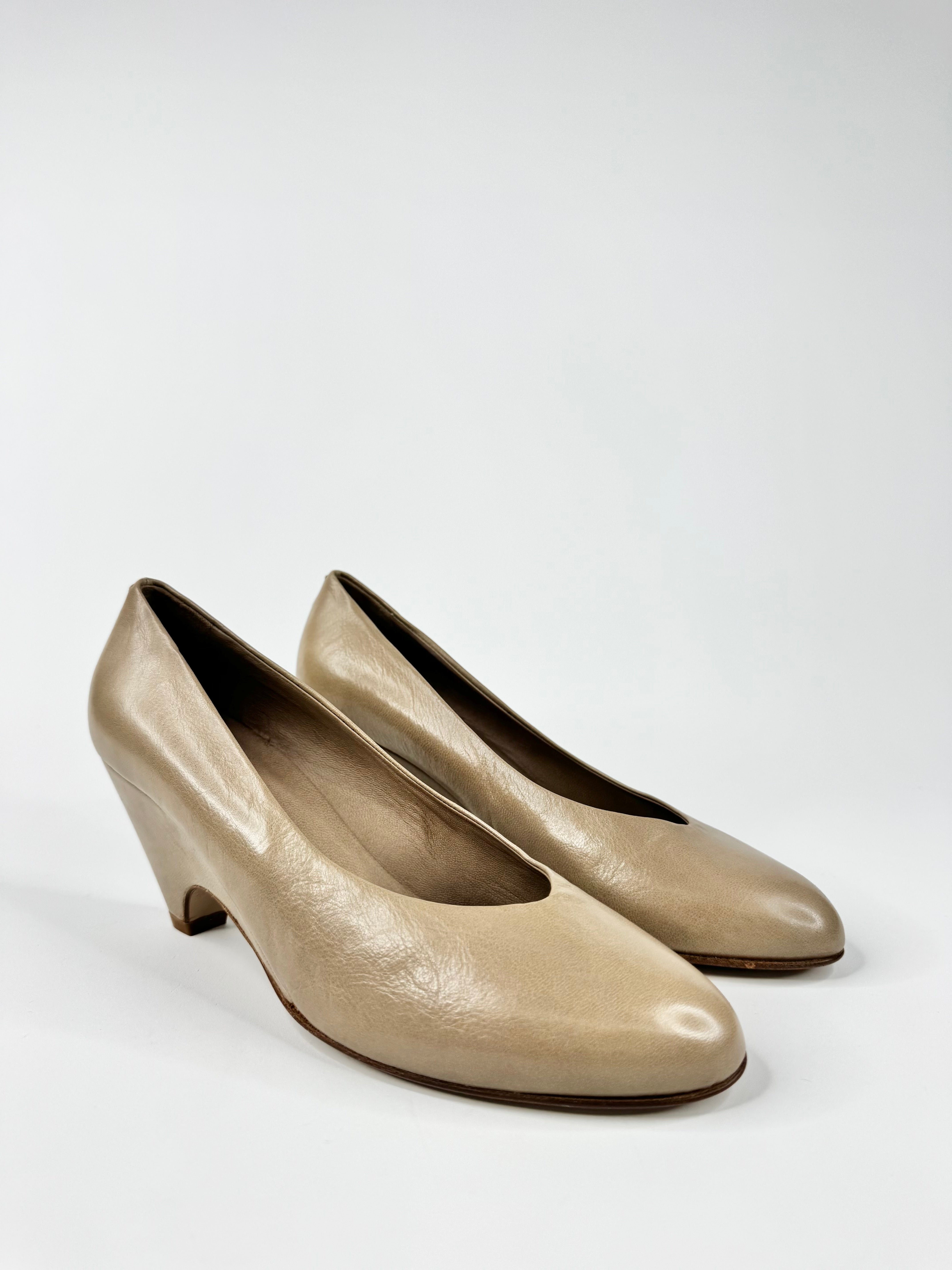 Pair of beige high-heeled shoes on a white background