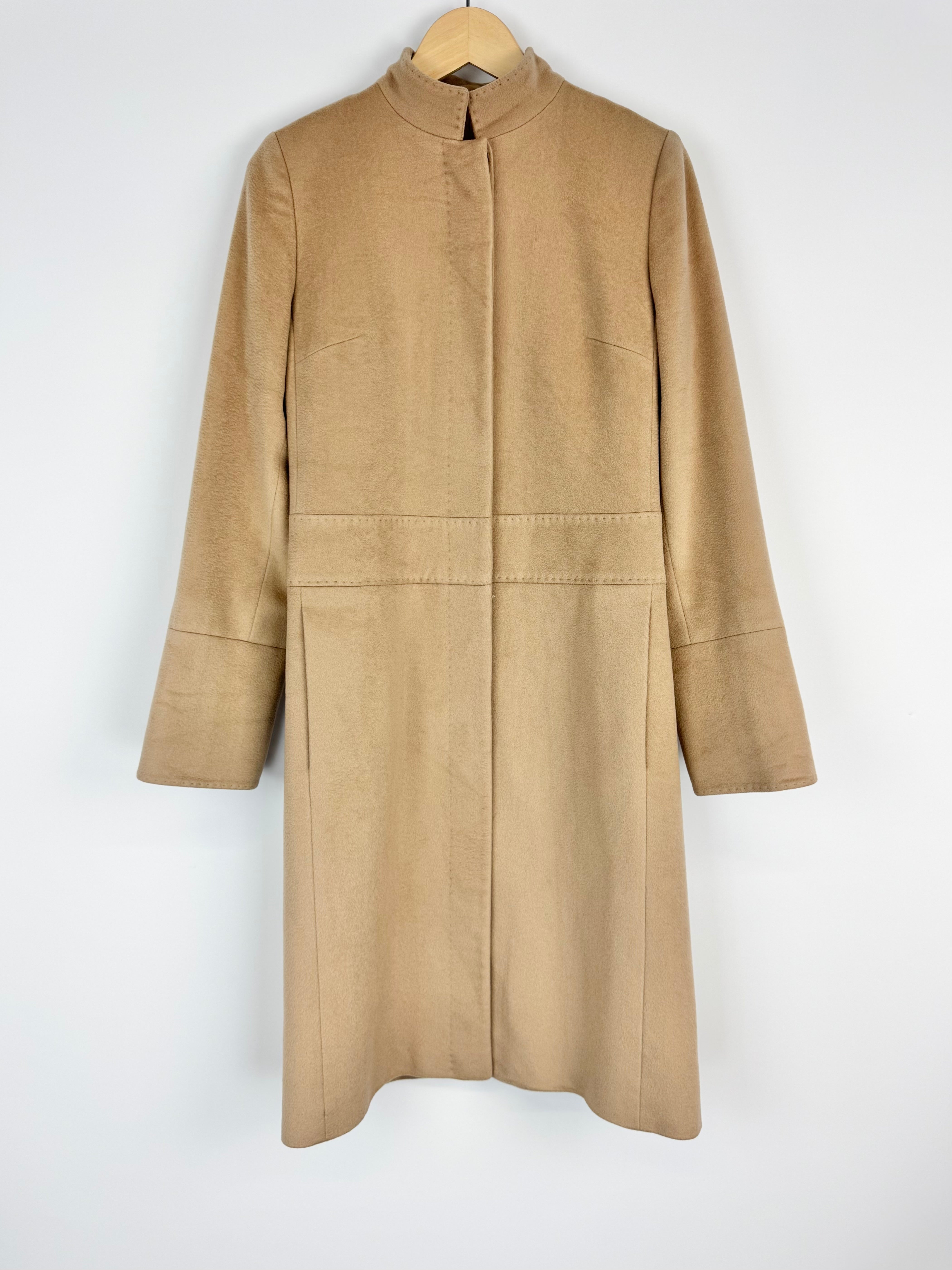 Beige coat on a hanger against a white background