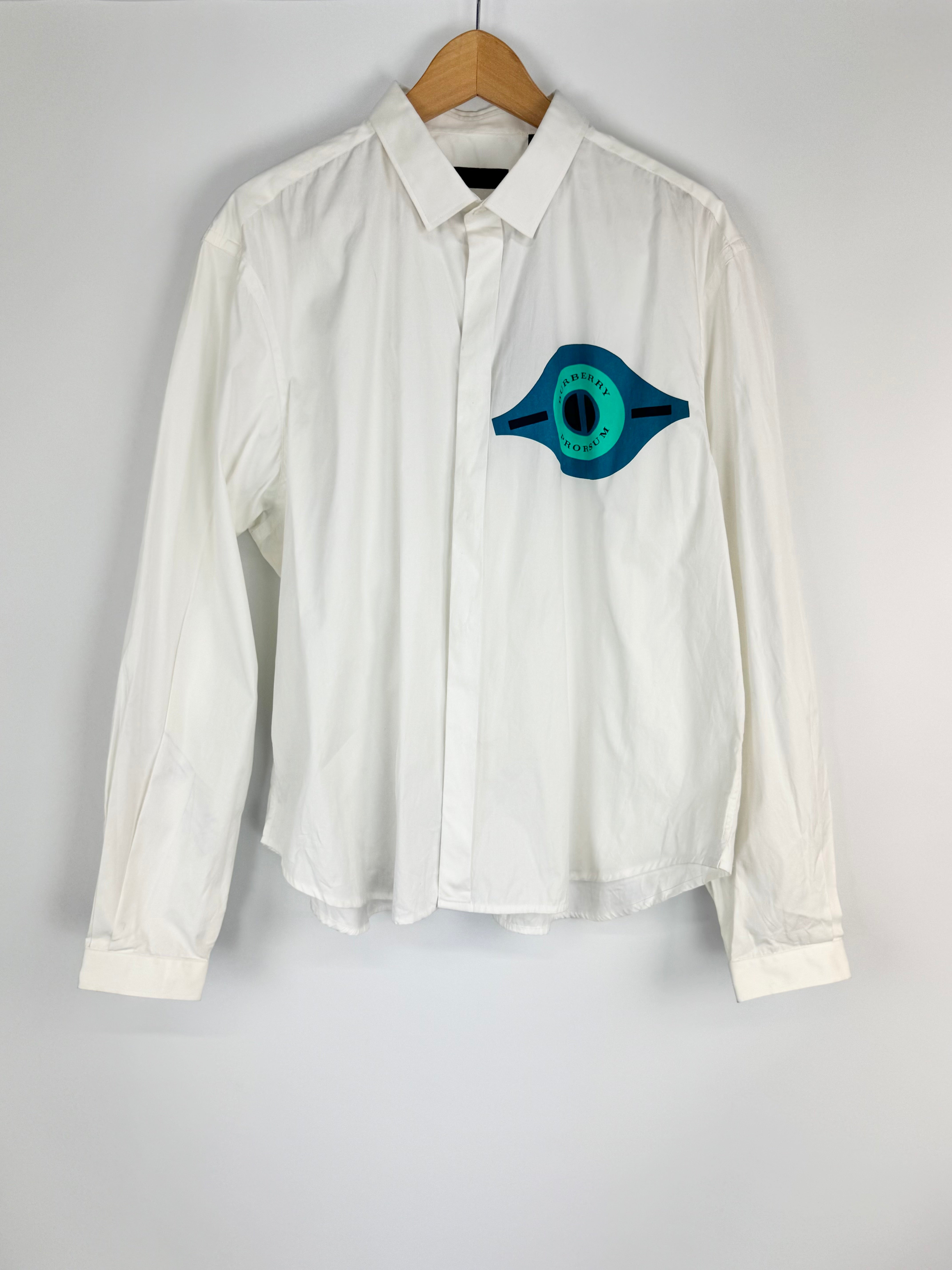 White shirt with a blue and green logo on a hanger against a gray background