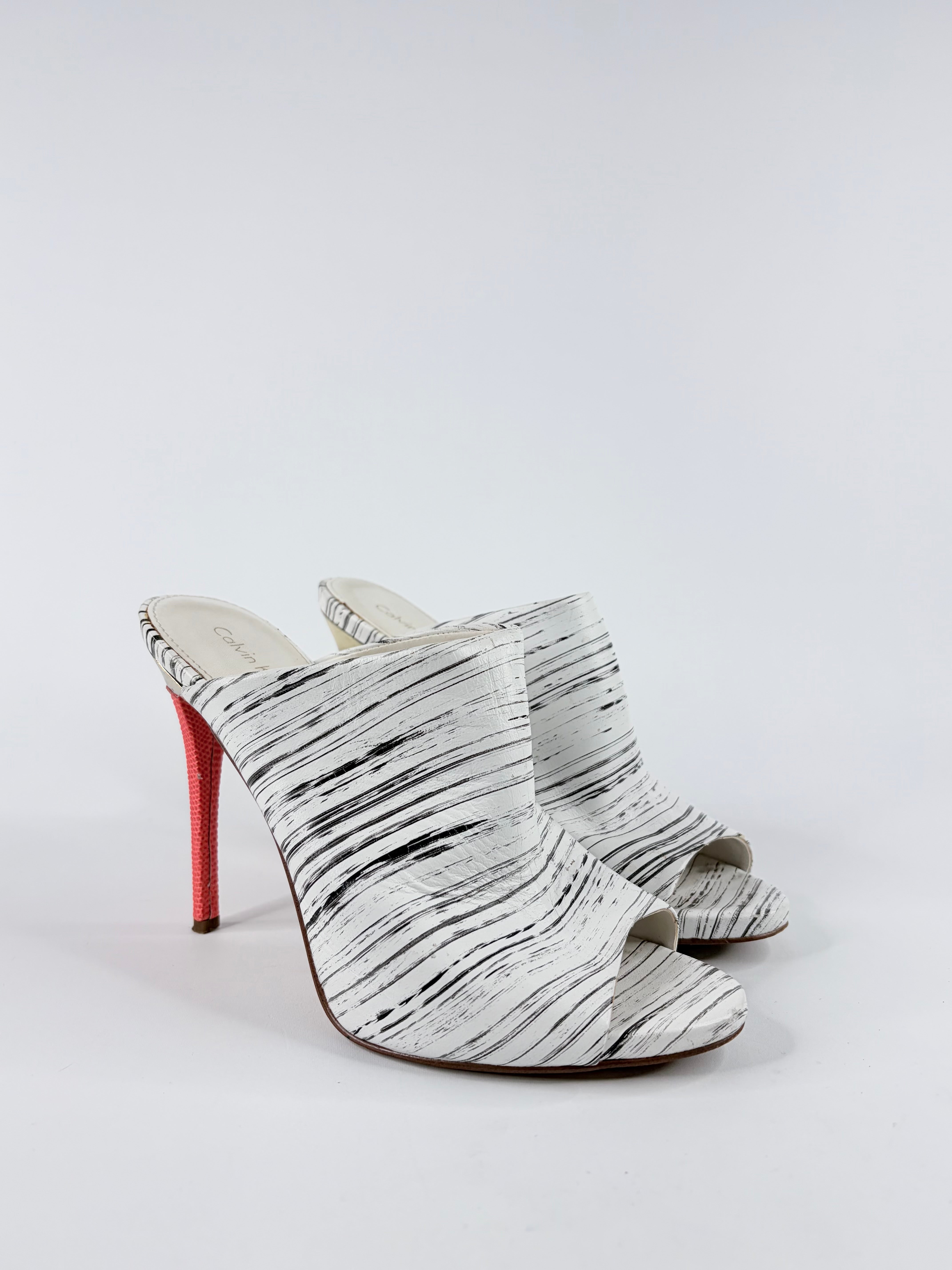White high-heeled shoes with red sole on a light gray background