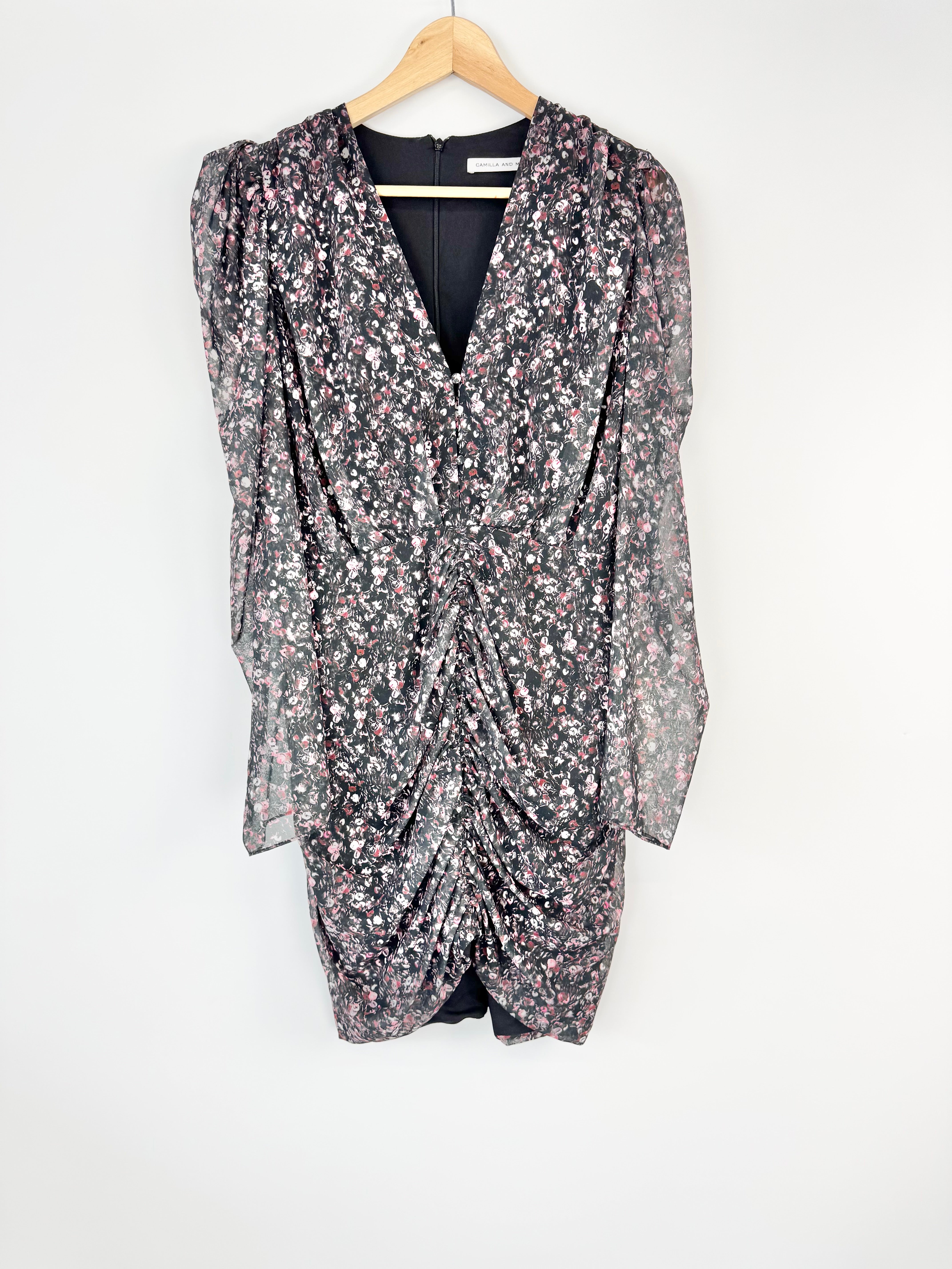 Sequined printed dress on a hanger against a white background