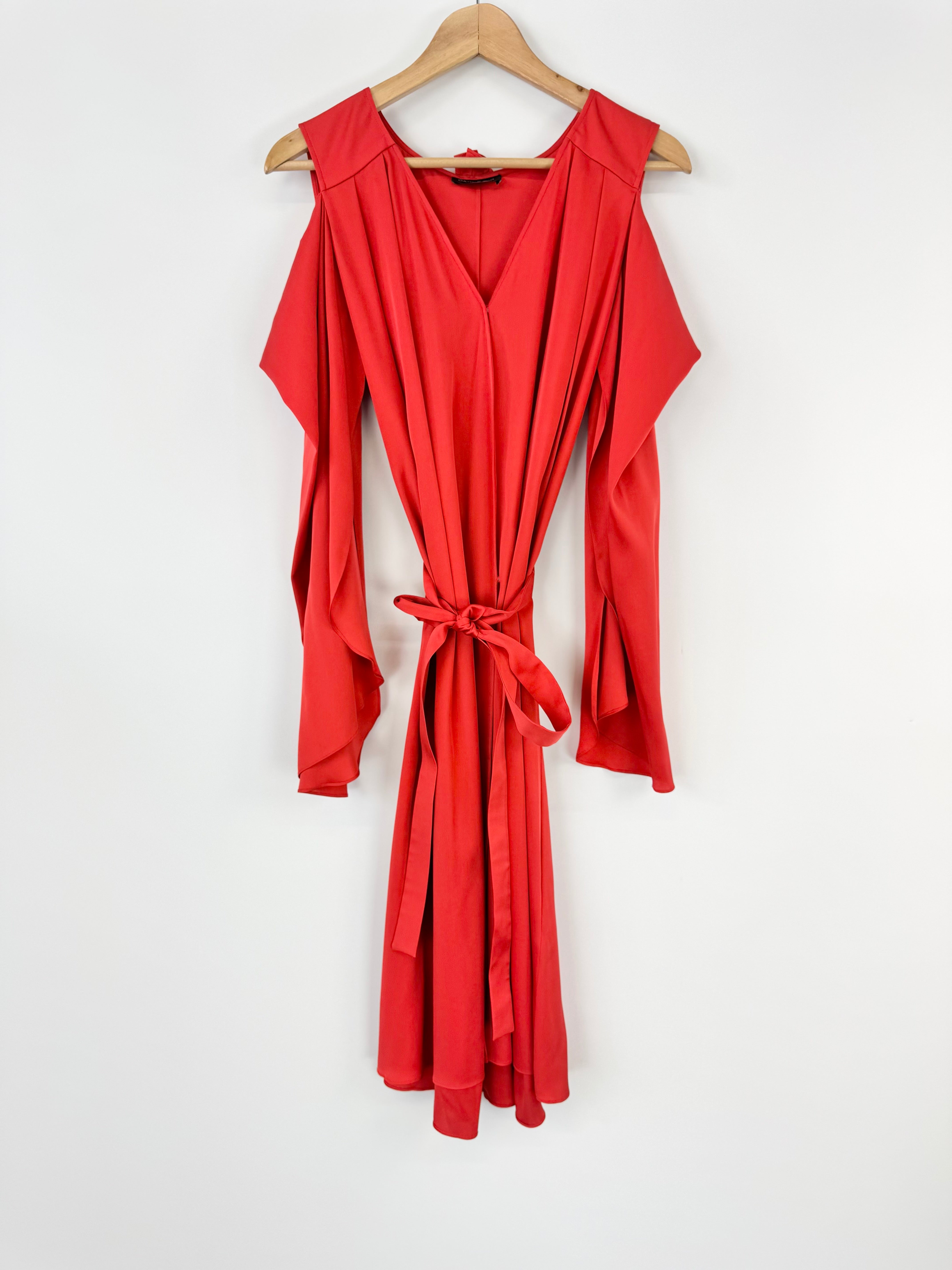 Red dress on a wooden hanger against a white background