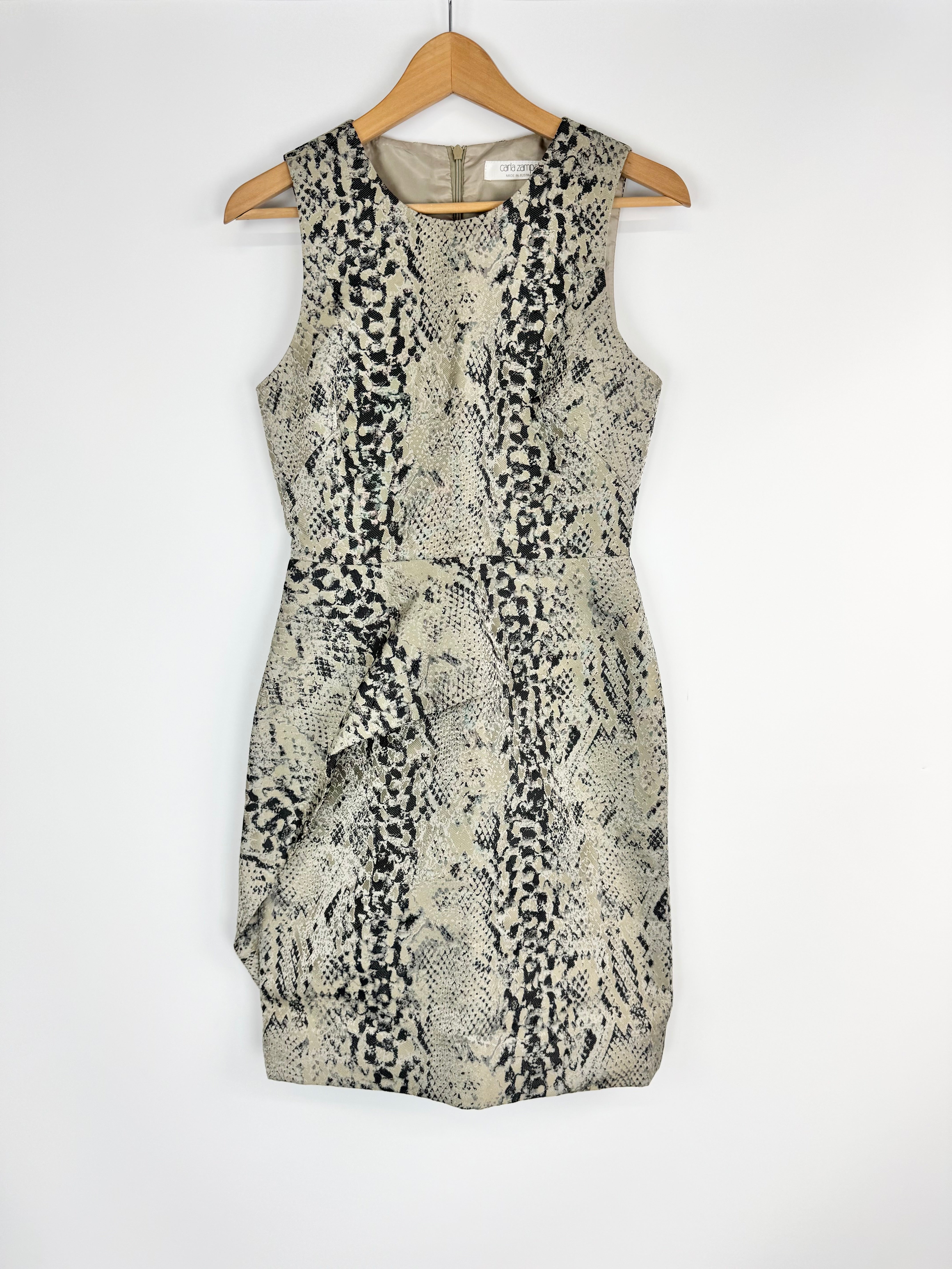 Patterned dress on a wooden hanger against a white background
