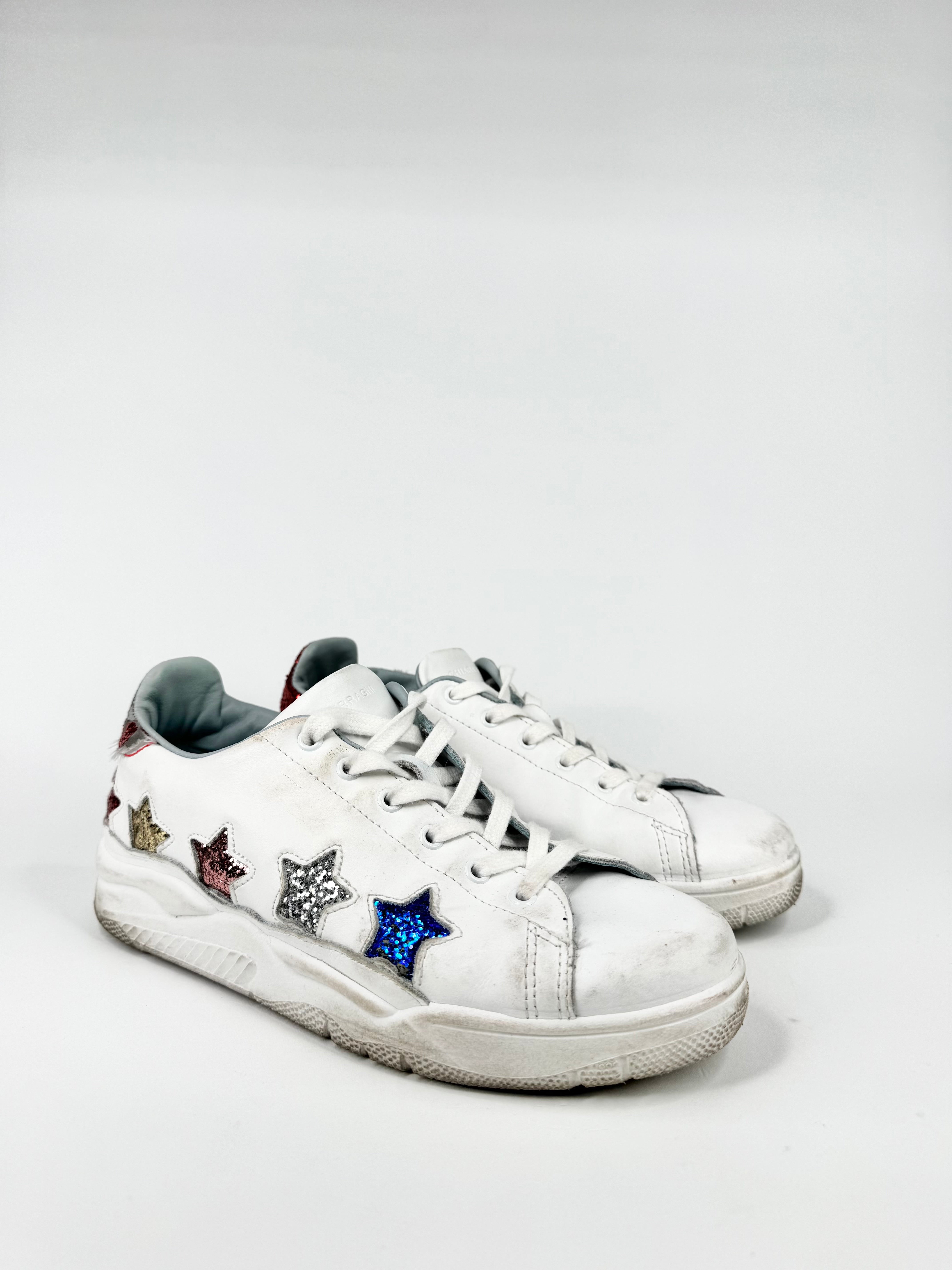 White sneakers with star designs on a light gray background