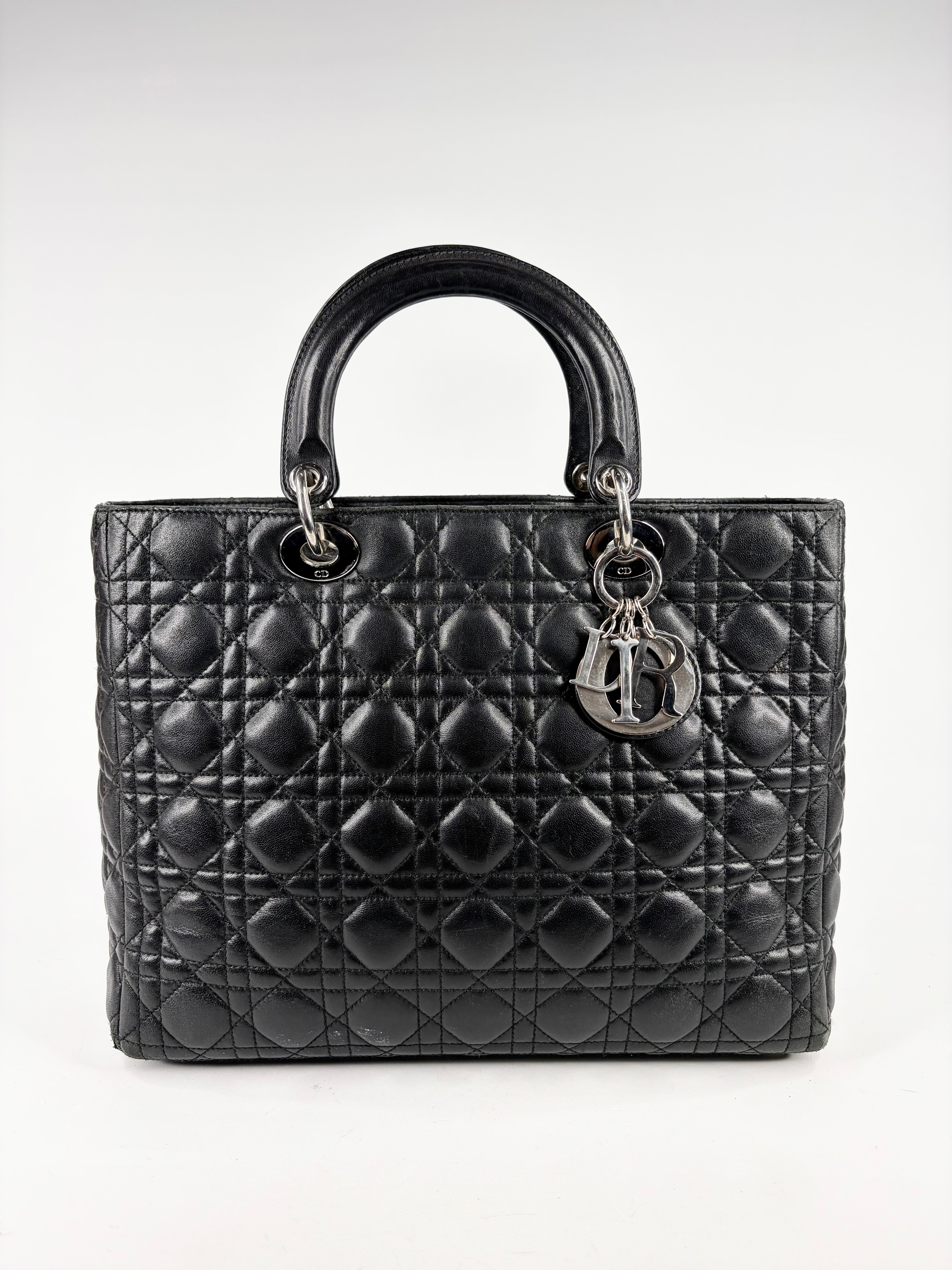 Black quilted handbag with a brand logo on a white background