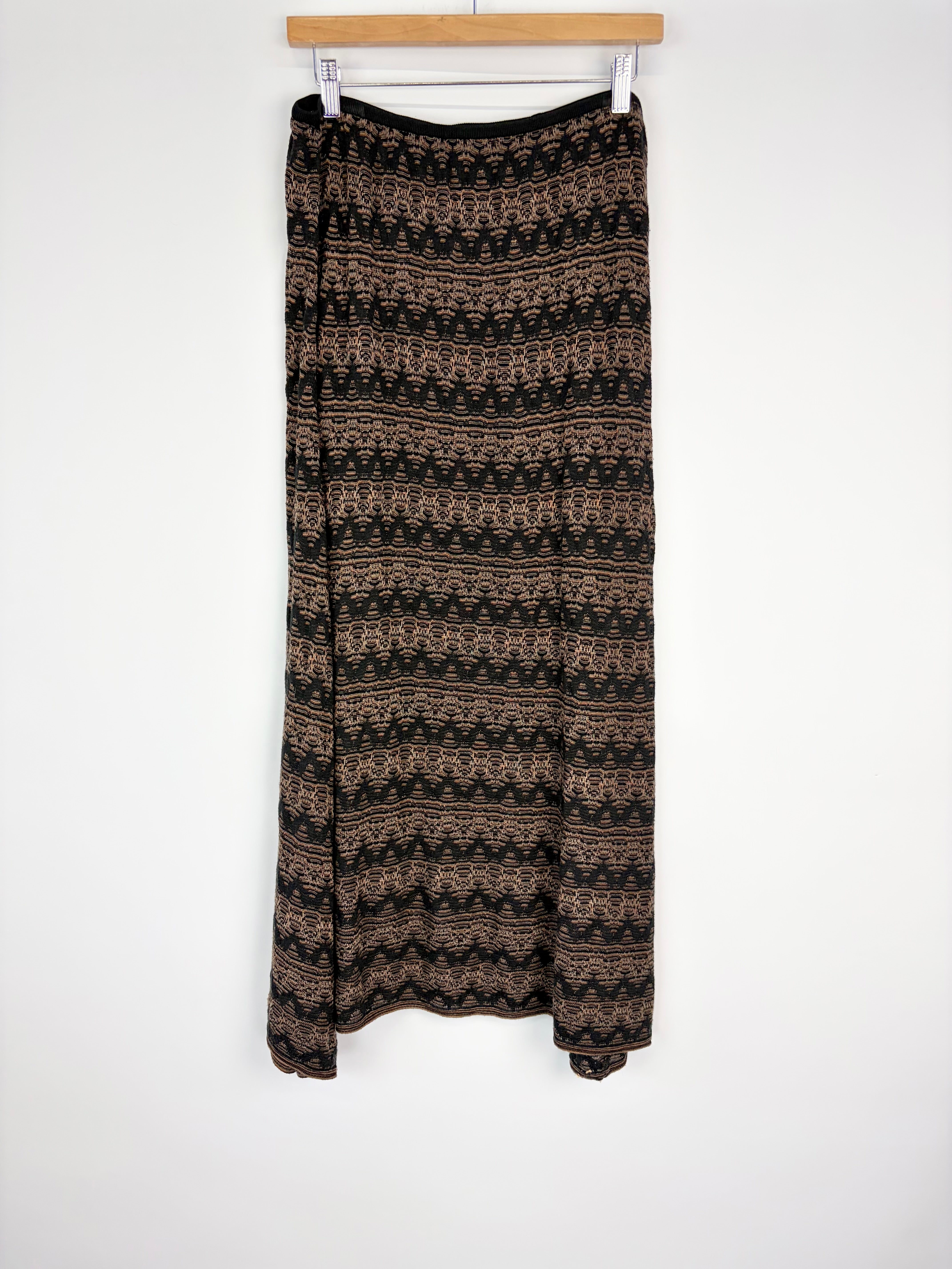 Patterned skirt hanging on a wooden hanger against a white background