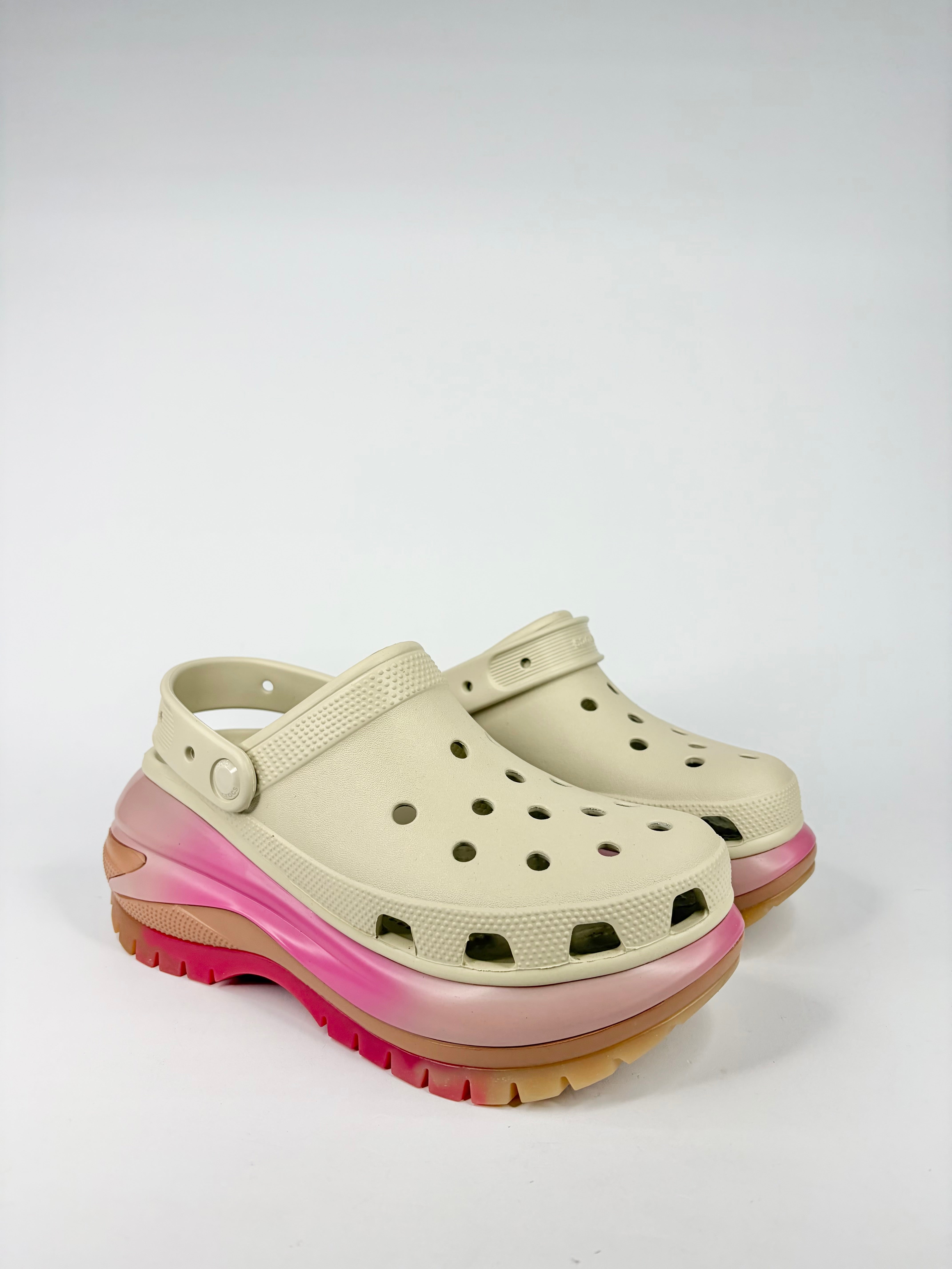Beige clogs with pink and brown gradient sole on a white background