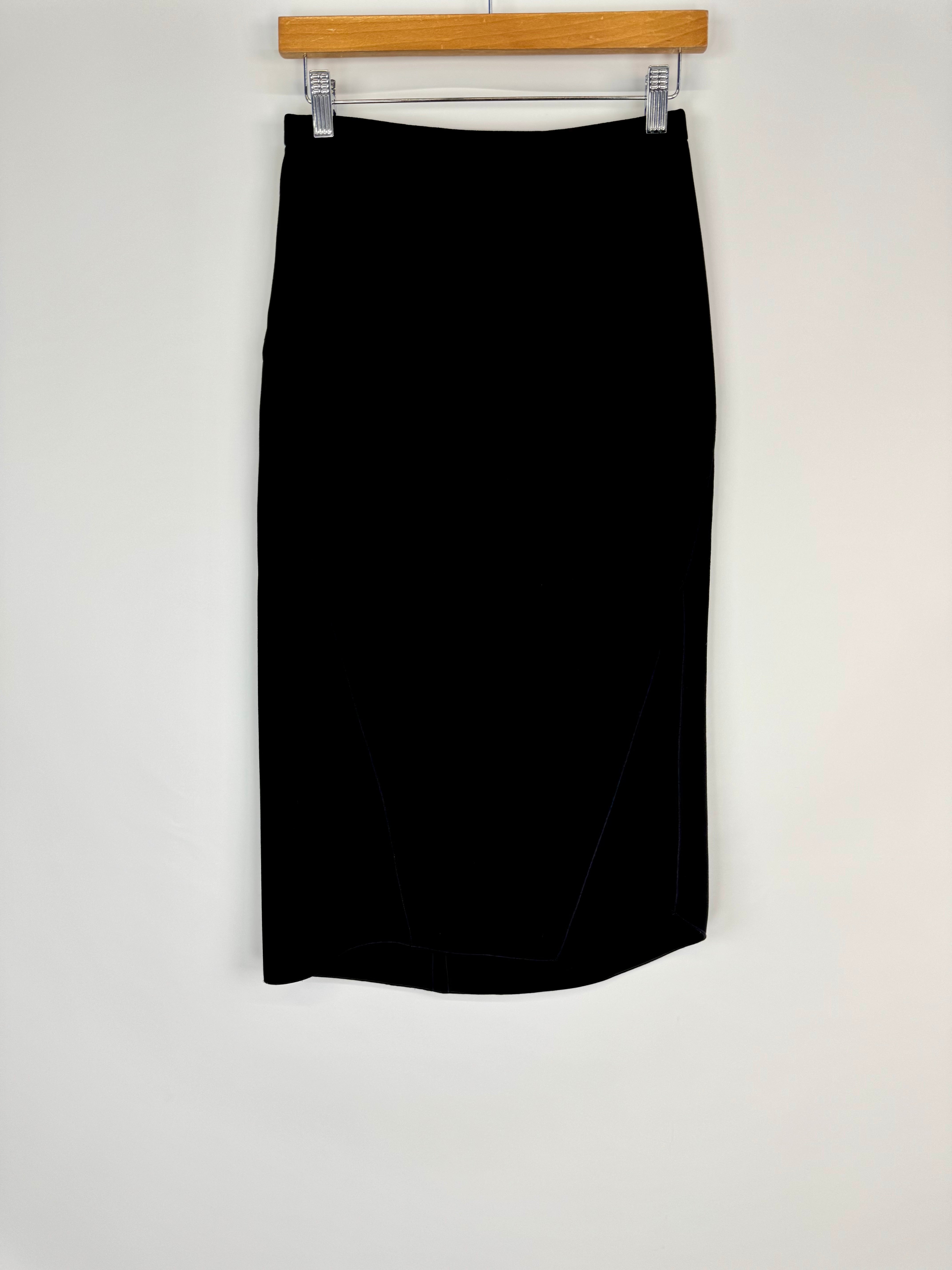 Black skirt hanging on a wooden hanger against a white background